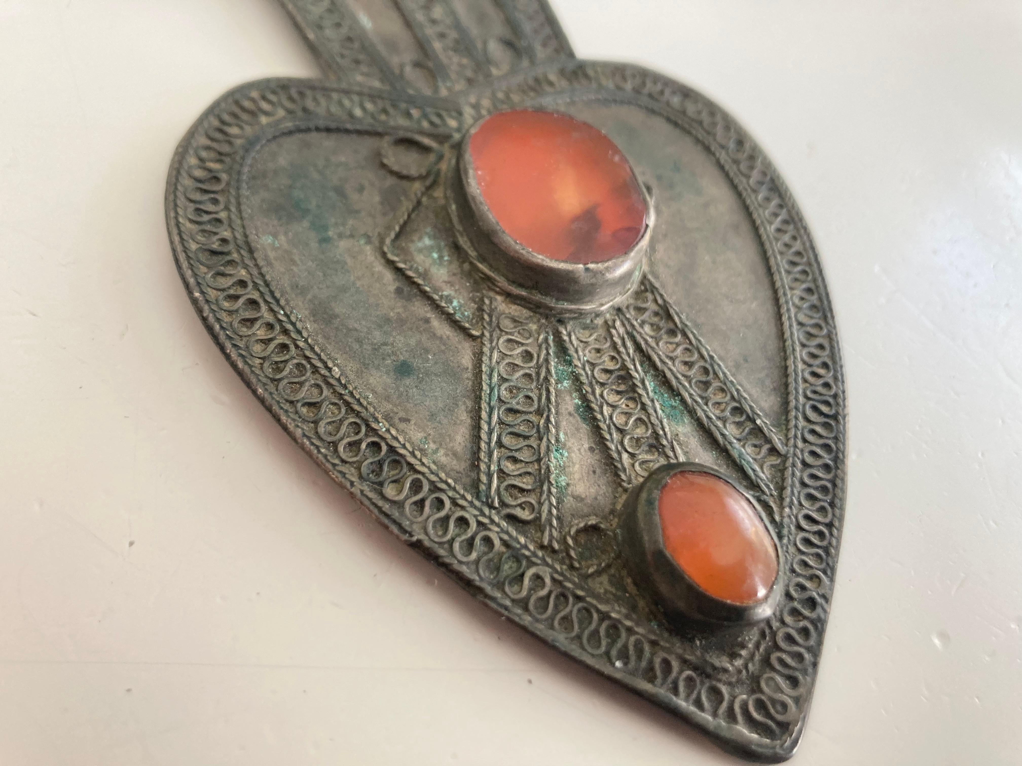 Classic larger Turkmen pendant with inset Carnelian on the traditional Heart form backplate with fine swirl details to the border. The Pendant with silver content material has a tubular opening at the top  for a hanging thong and the back has an old