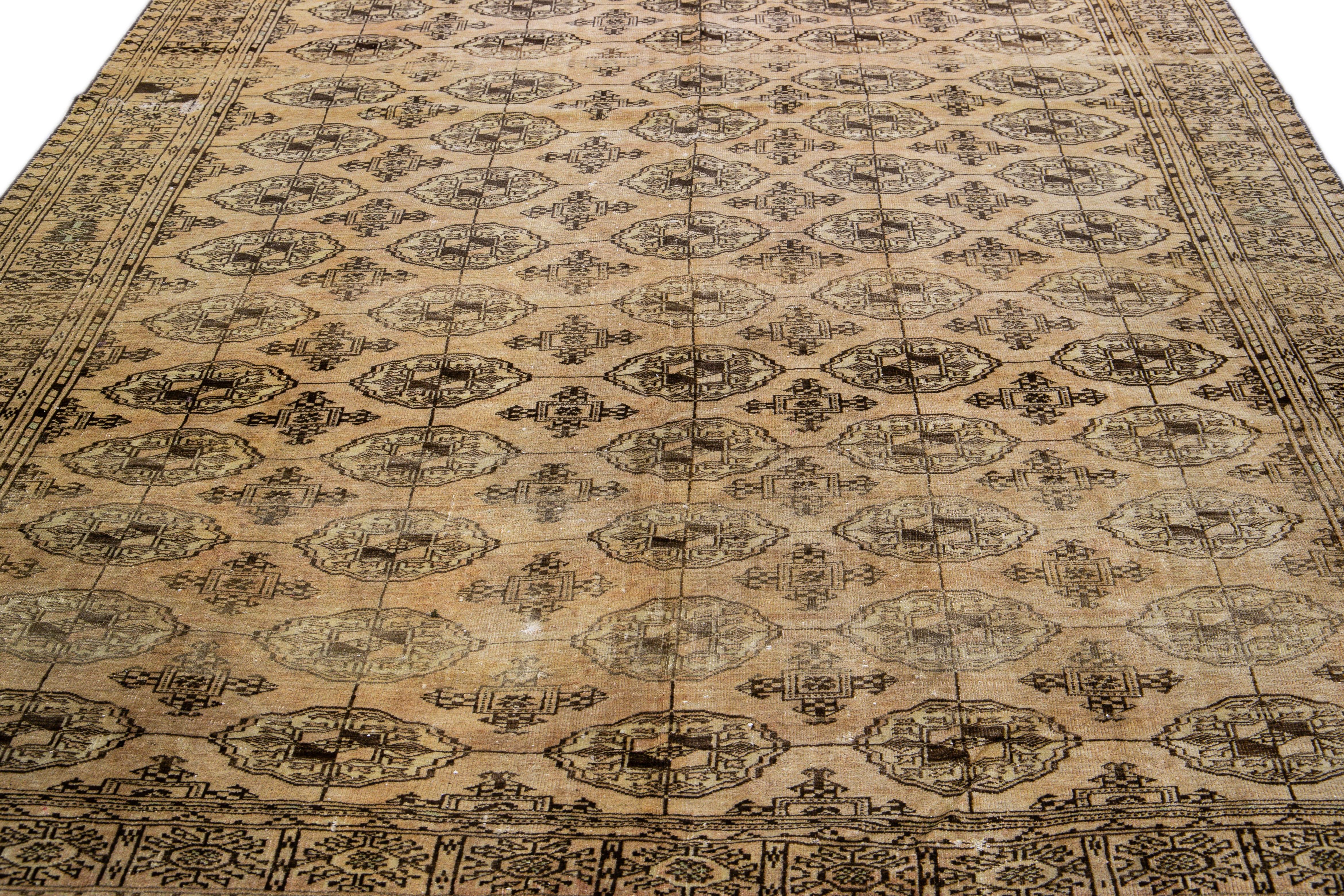 Beautiful antique Turkmen hand-knotted wool rug with a beige field. This piece has brown accents in an all-over geometric pattern design.

This rug measures: 7'4