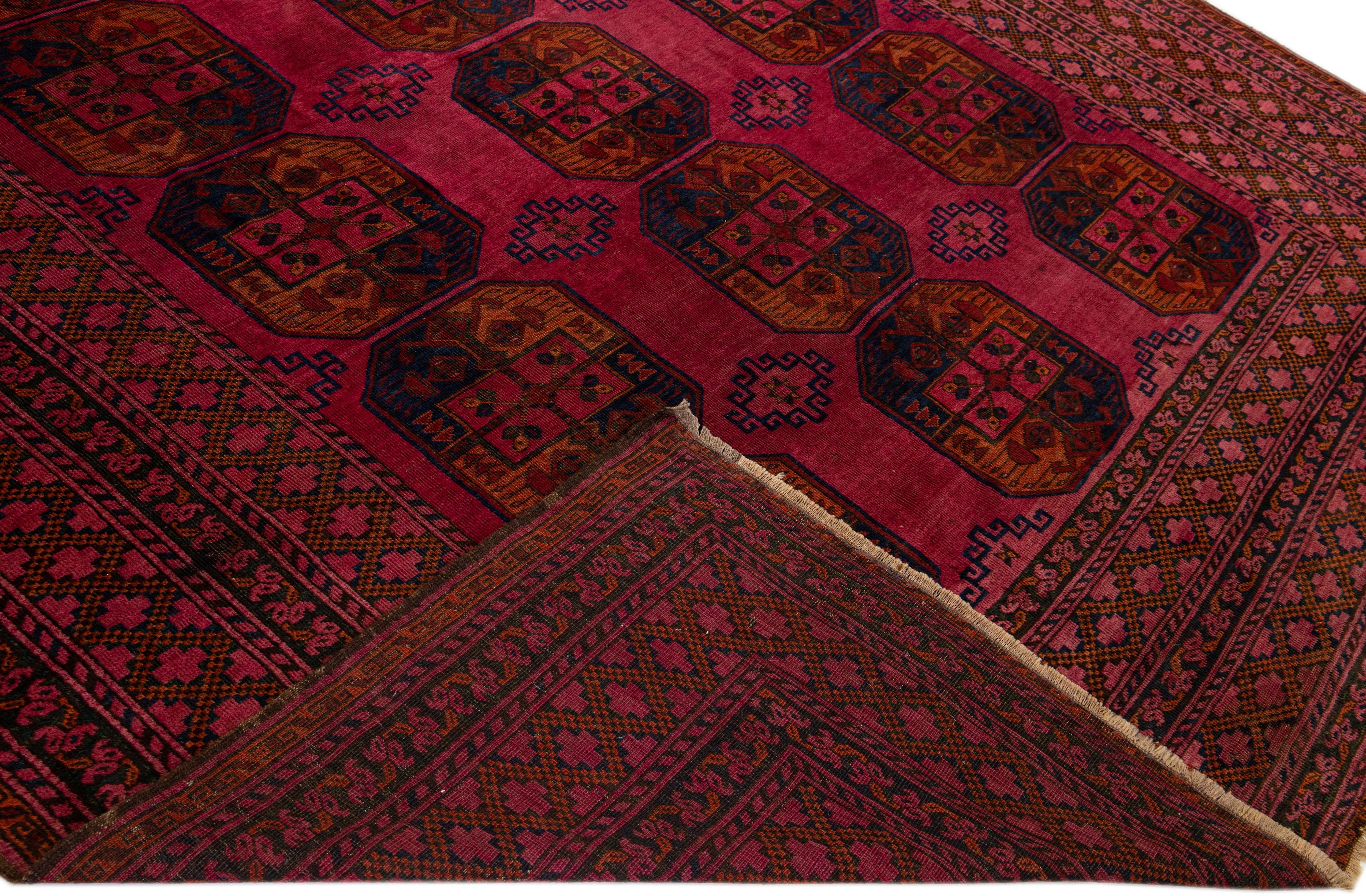 Beautiful antique Turkmen hand-knotted wool rug with a red field. This piece has brown accents in an all-over gul pattern design.

This rug measures: 10' x 19'.