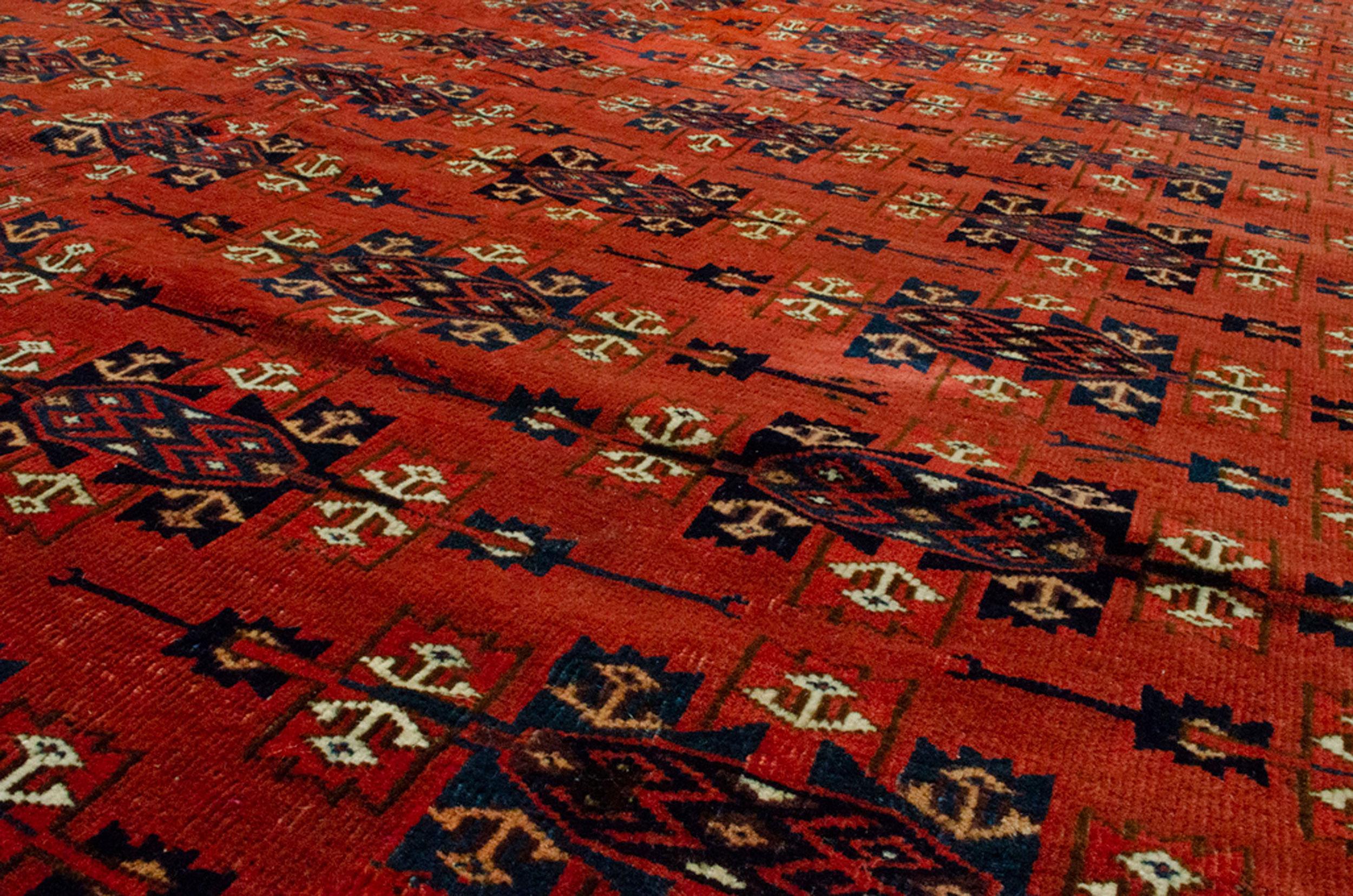 Turkmen carpets have always been a sought after decorating items. They are suitable as a library rug or a dining room rug, as they are all over design. This Yamoud Turkmen with its all over Kepse Gul on a rich red background and a vine and curl leaf