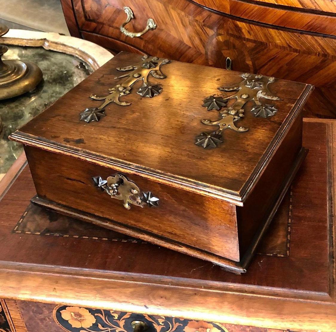 Turn of the century German walnut box with brass decoration on the top of the box and the bottom. Original key.