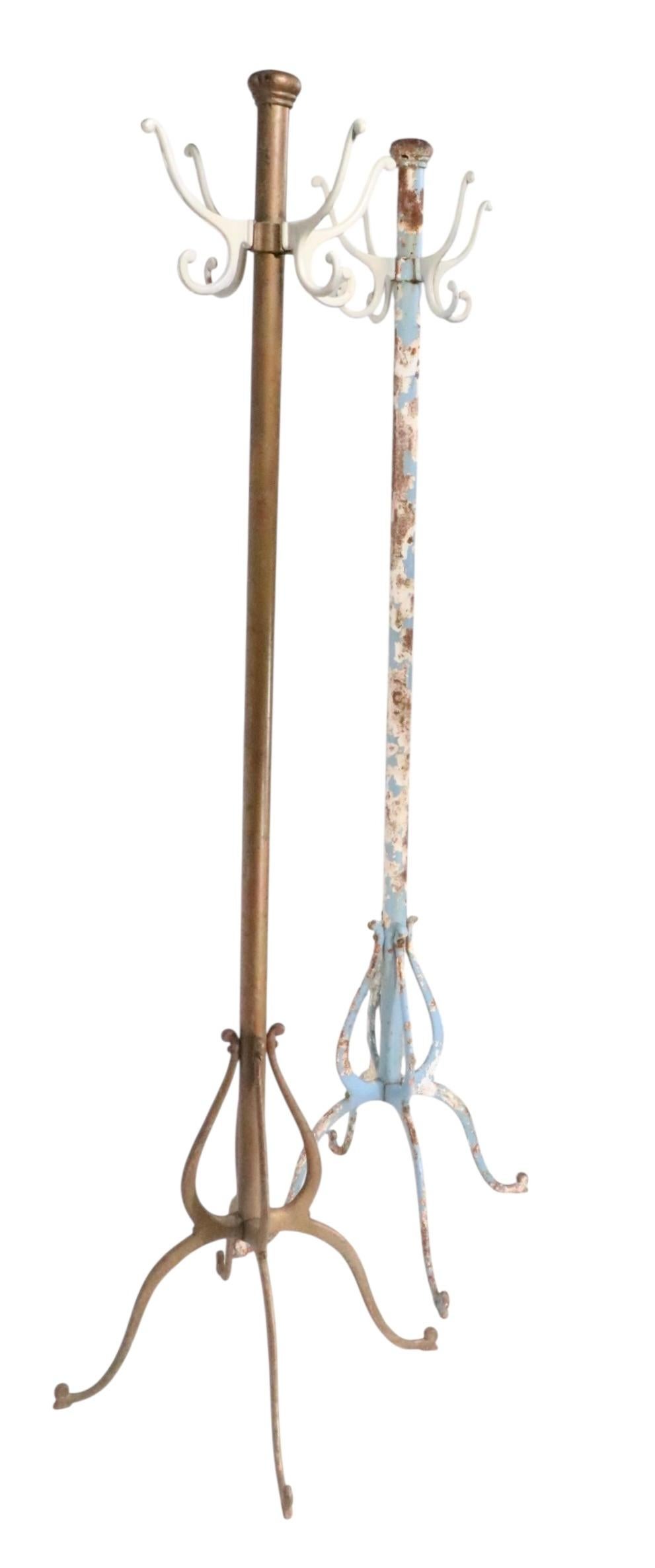Industrial style coat rack ( s ) constructed of cast iron and steel, having four arms at the top, each with two hooks, upper hooks for coats or hats , lower for scarves etc. Both are structurally sound and sturdy, both have been repainted and show