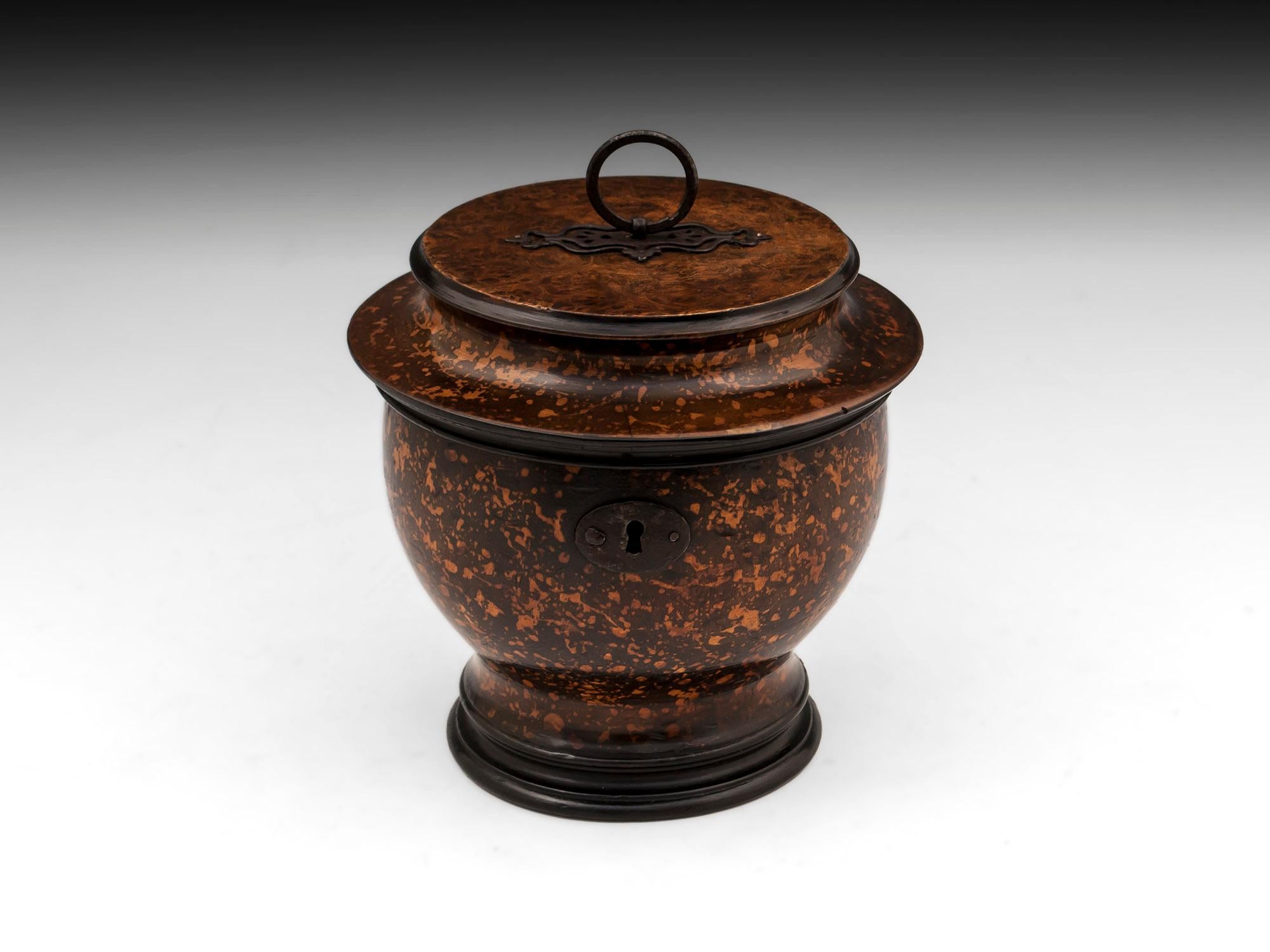 Antique wooden turned urn shaped tea caddy with wonderful dark green mottled decoration similar to the Melon fruit tea caddies. The top is has a tight bur and has ornate cut steel back plate and handle, with the front having a oval escutcheon

The