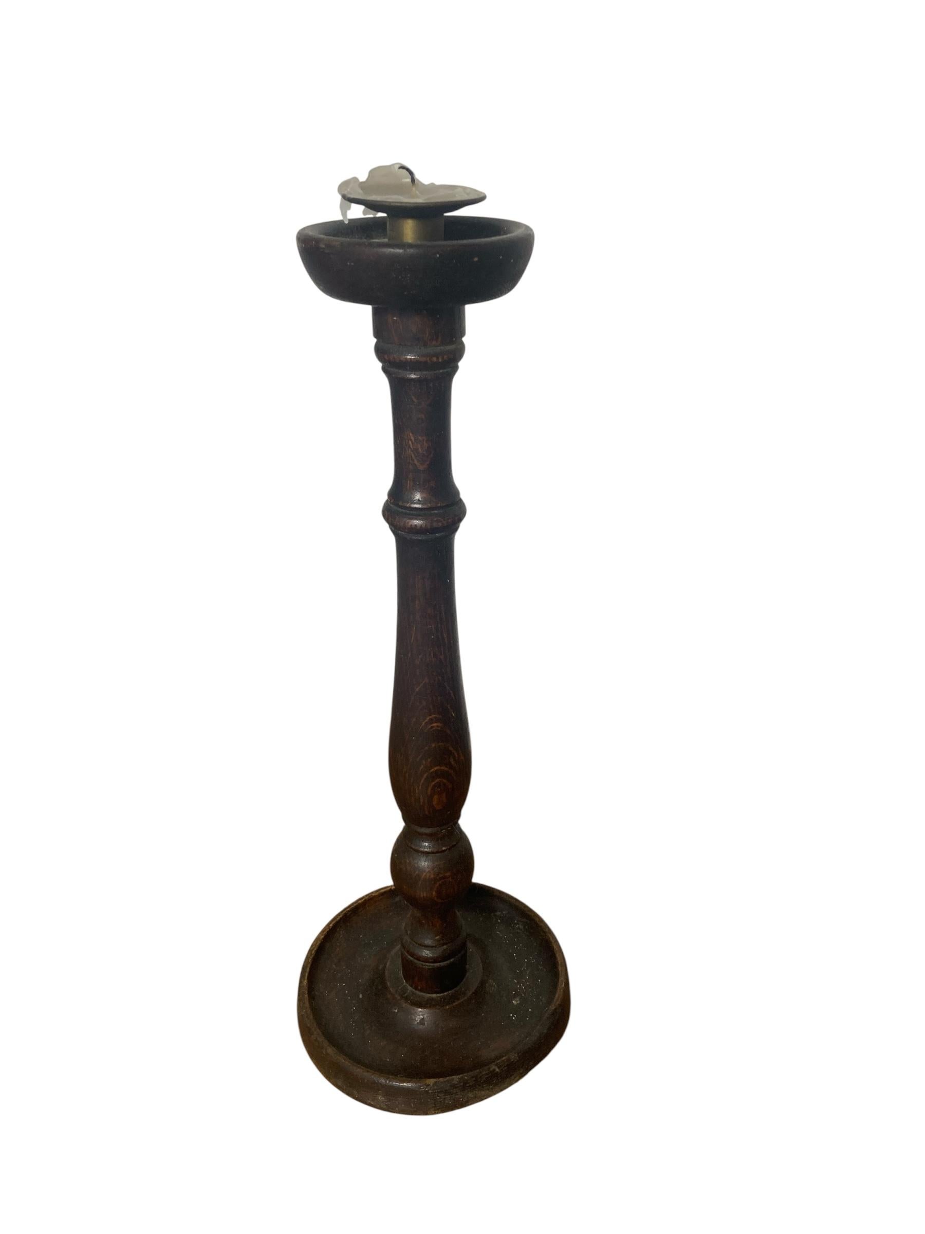 Antique turned wooden candle holder Circa 1800's. Elevate your home decor with this exquisite candle holder, featuring a sturdy wooden base complemented by a sleek turned wooden stand. Its elegant design seamlessly blends rustic charm with modern