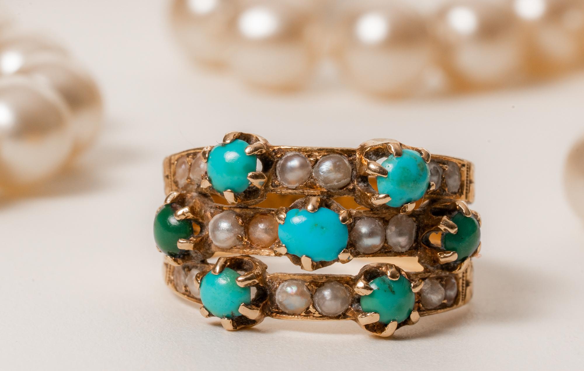 A vintage harem gold ring with bright turquoise and delicate pearl decoration!

The beautiful ring features three gold bands that are connected in the back. 7 natural turquoise orbs and 18 split pearls are held in by prongs. Ring total weighs 3,8