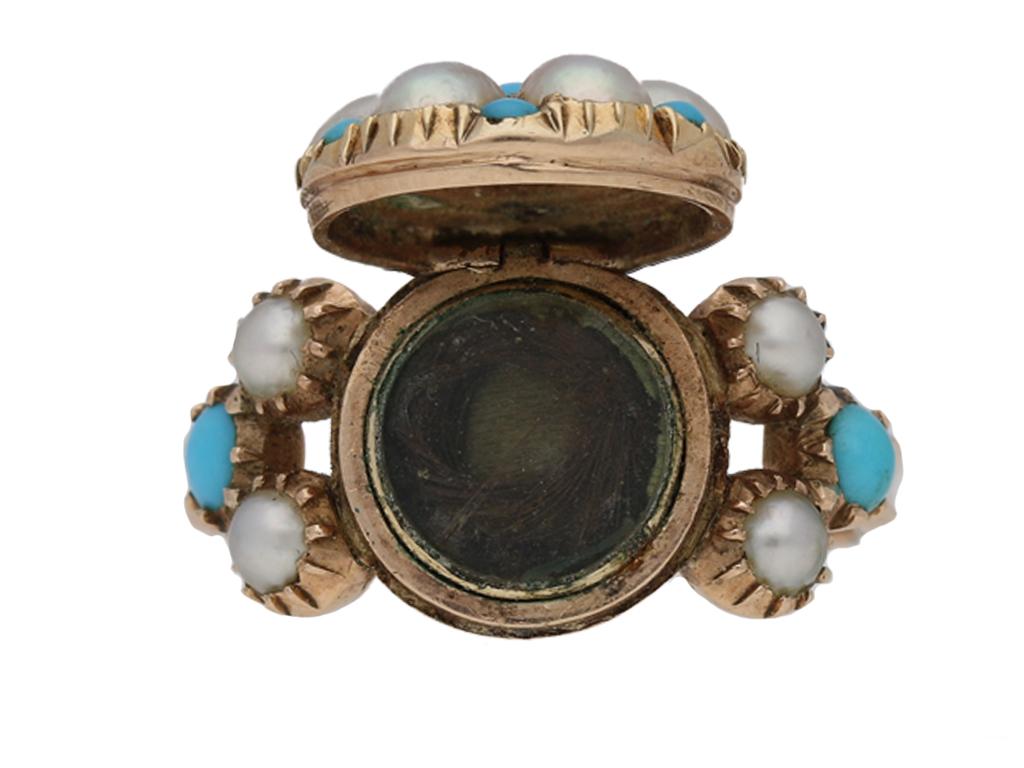 Antique turquoise and pearl locket memorial ring. The circular bezel is set with one central cabochon turquoise in a closed back grain setting, encircled by six pearls and six smaller cabochon turquoises all in closed back cutdown settings, the