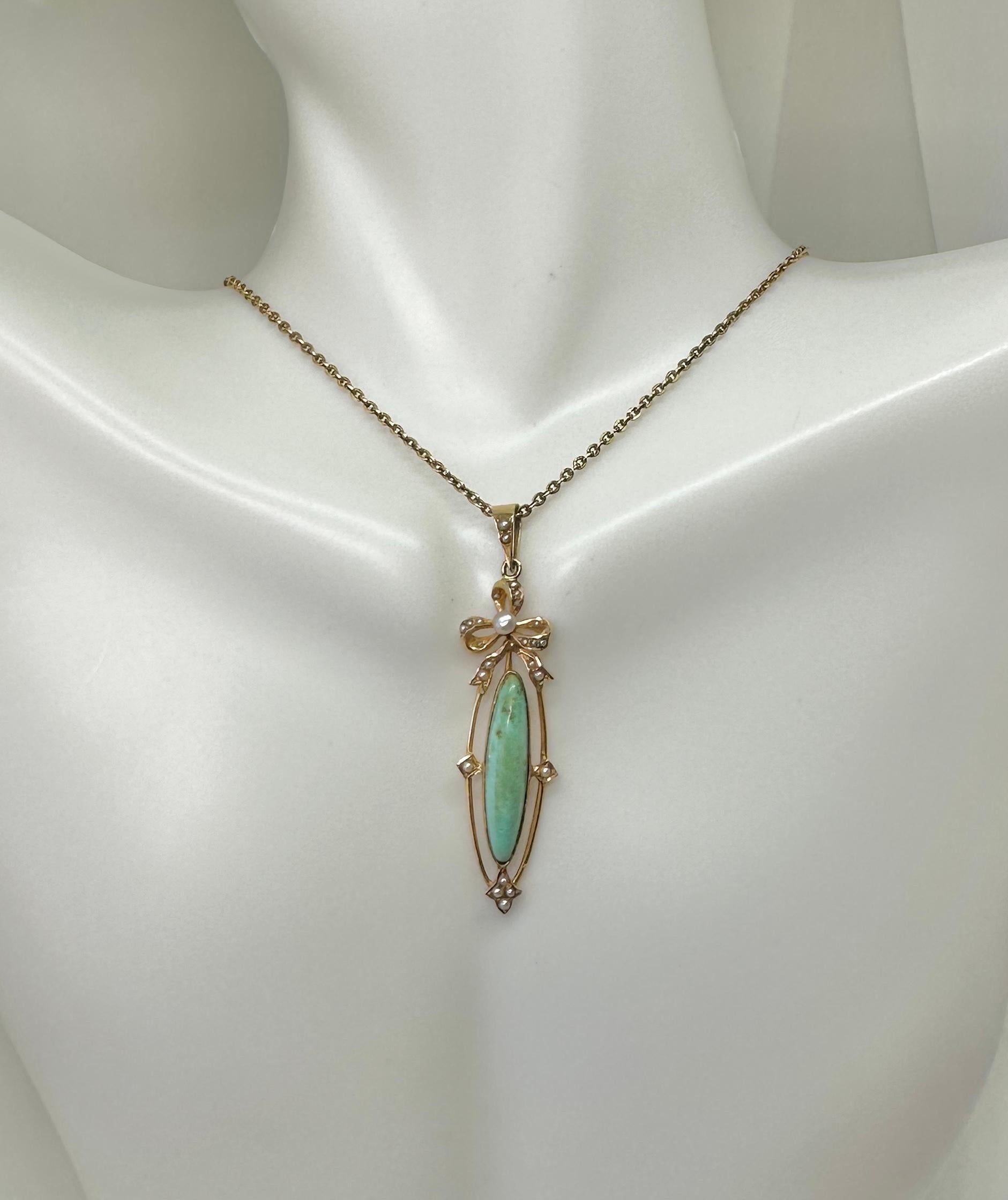 This is a stunning Victorian Antique 14 Karat Gold Turquoise and Pearl Bow Motif pendant and necklace chain. The pendant features a gorgeous long oval turquoise cabochon.  The turquoise is set in an open work design surrounded by pearls with a pearl