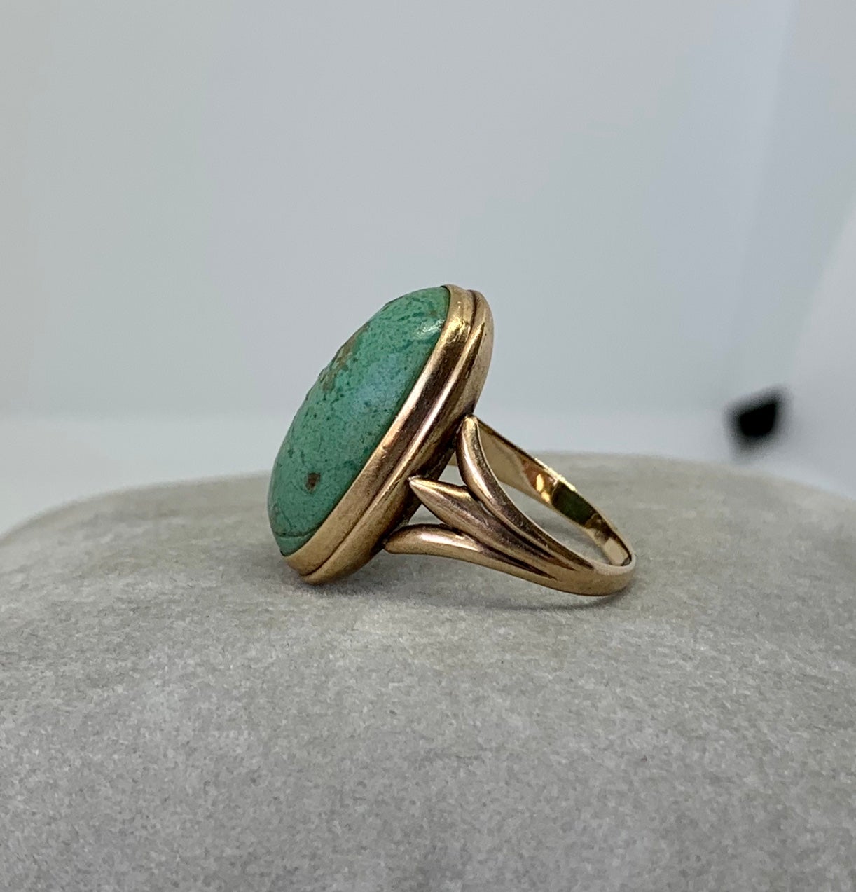 This is a gorgeous antique Turquoise Ring with a stunning 19mm by 10mm by 5mm Turquoise Cabochon.  The Turquoise is set in two lovely bands of gold with a wonderful scroll motif shank in 10 Karat Yellow Gold.  The vivid oval Turquoise cabochon is of