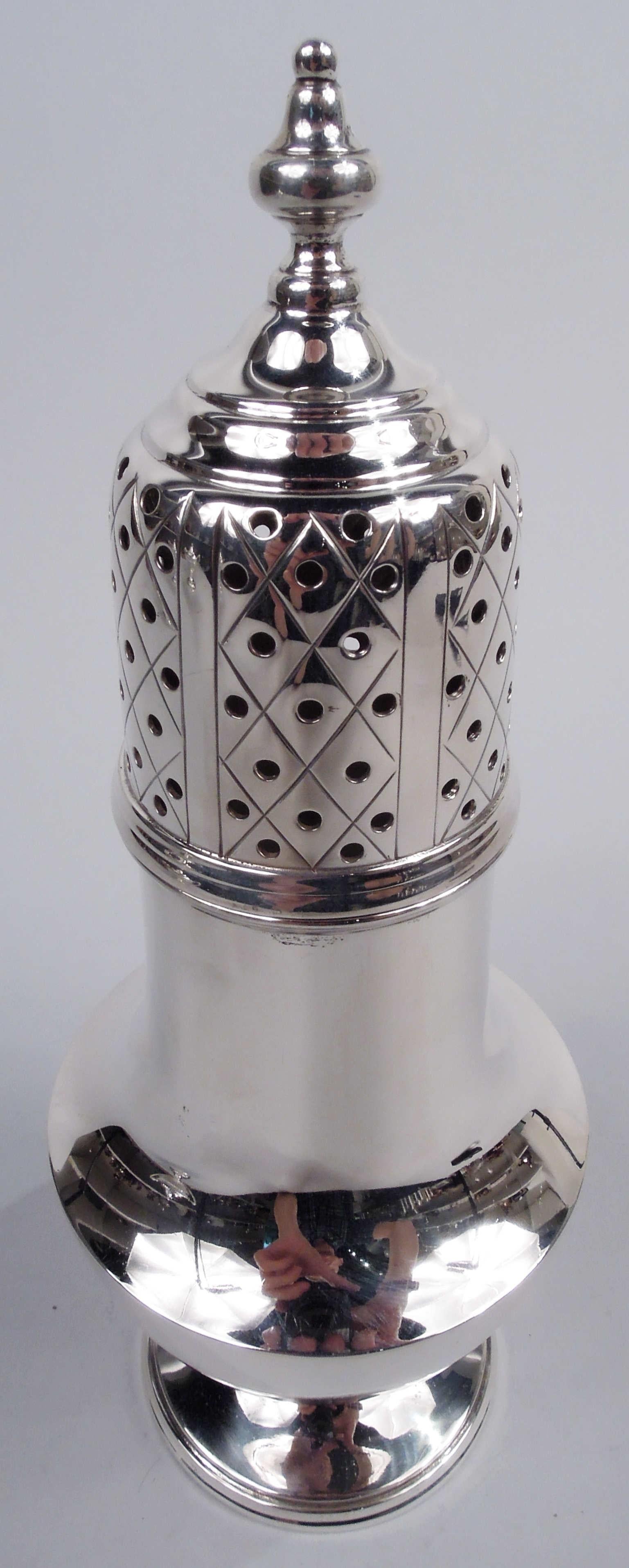 Edwardian Georgian sterling silver sugar caster. Made by Tuttle in Boston, ca 1910. Baluster on stepped round foot. Cover has stepped top with vasiform finial; sides pierced with engraved diaper. Fully marked including maker’s stamp and no. 25.