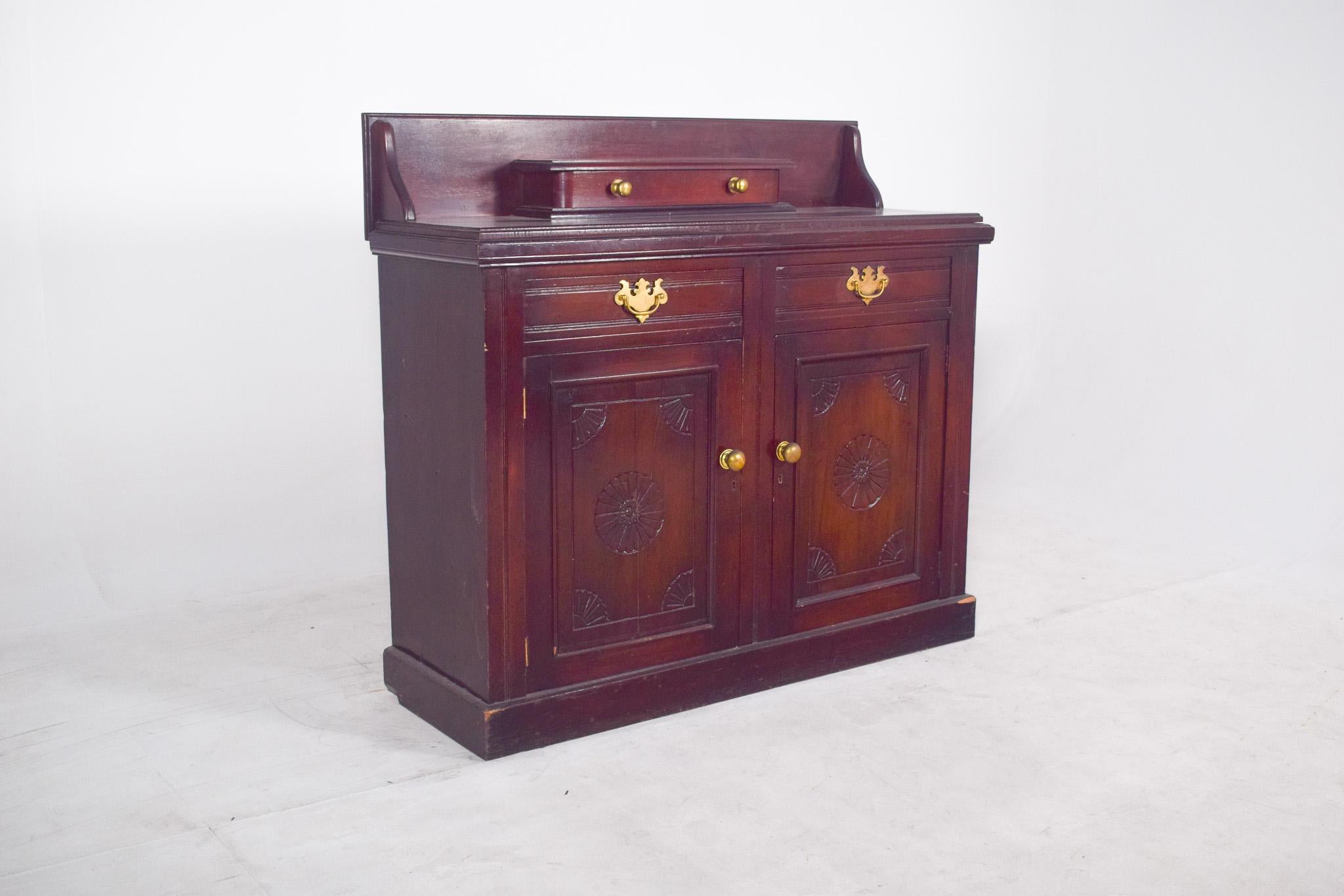 Two-door sideboard with raised section. In dark wood with a varnished finish, it has two doors at the bottom with decorative flower or star-shaped carvings and rounded metal handles. Above the doors are two drawers with classic-style brass handles,