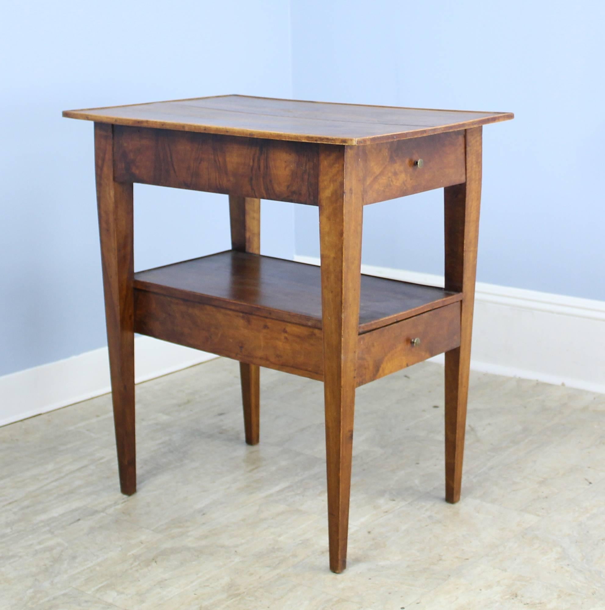 An unusual French antique walnut side table with two levels of drawers under a lovely two planked top with galleried edge. Good walnut color and grain and tapered legs give this piece a modern sensibility despite its age.