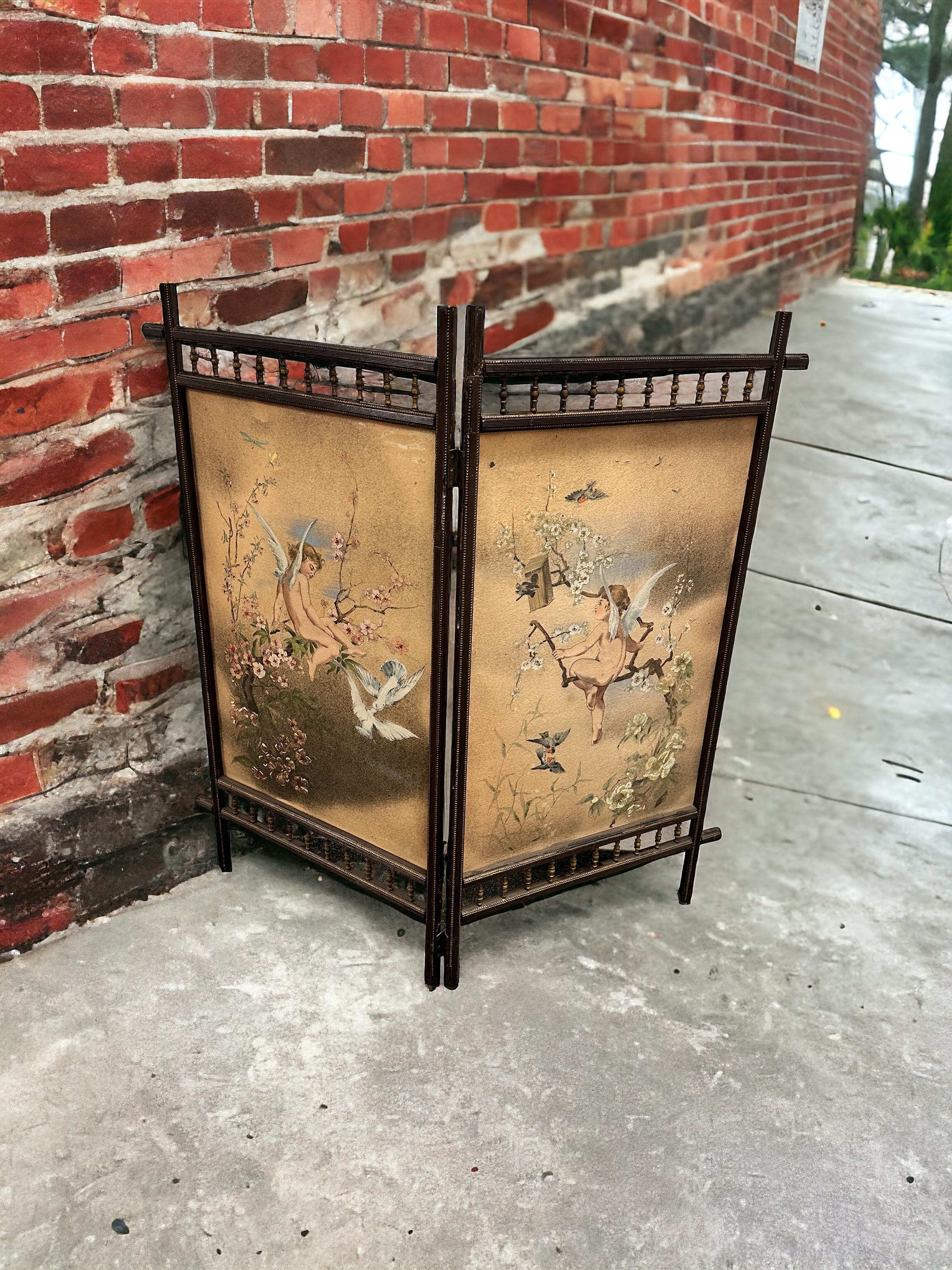 A petite German late 19th or early 20th century screen hand painted on fabric and wood, early 1900s
screen with wooden structure and fabric interior, hand painted on one side. The painted subjects represent two cherub Angels with birds. Can be used