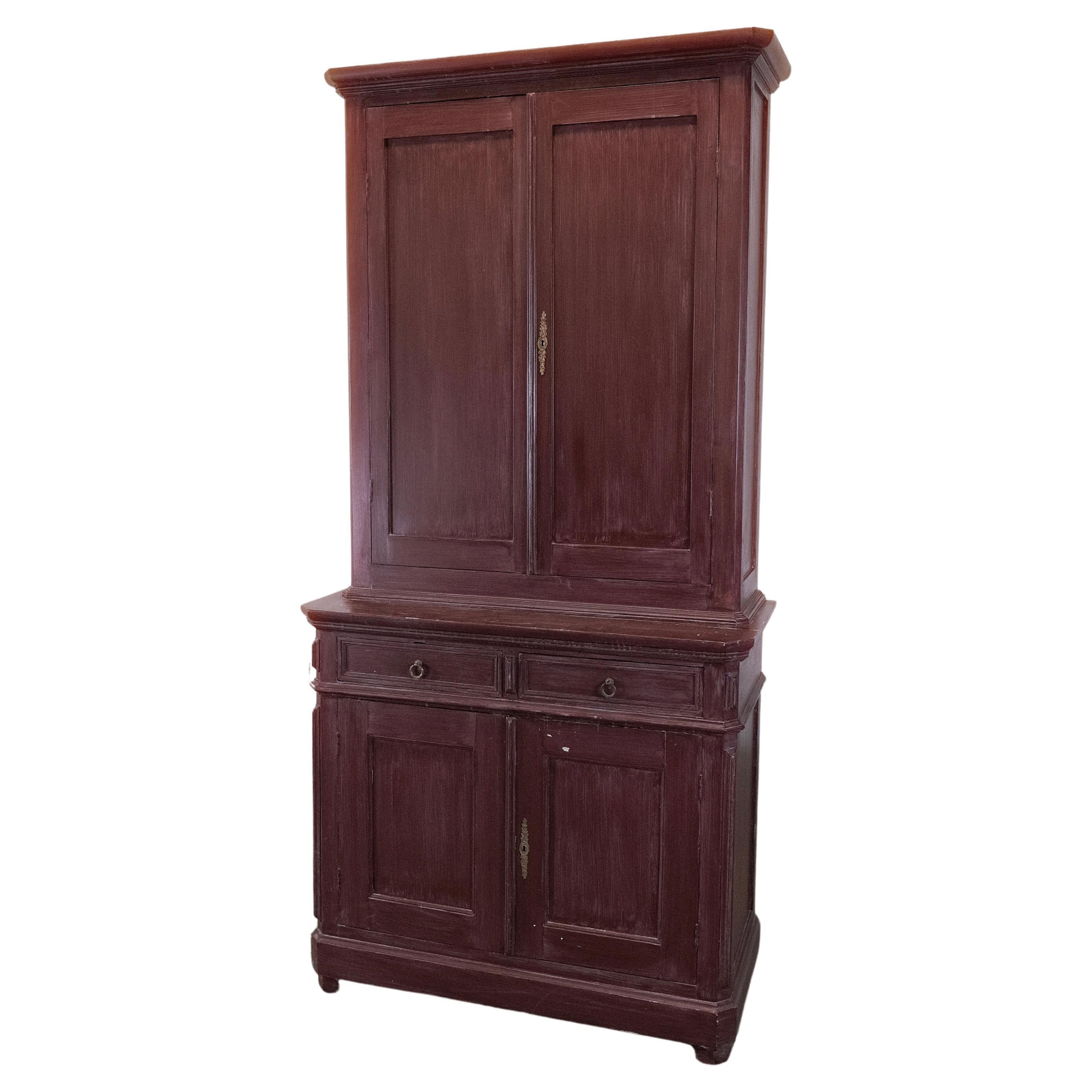 Step into a world of vintage charm with this antique two-piece pine cupboard, a piece that beautifully marries functionality with whimsical elegance. Its exterior, crafted from aged pine, carries the character of time, while a delightful surprise