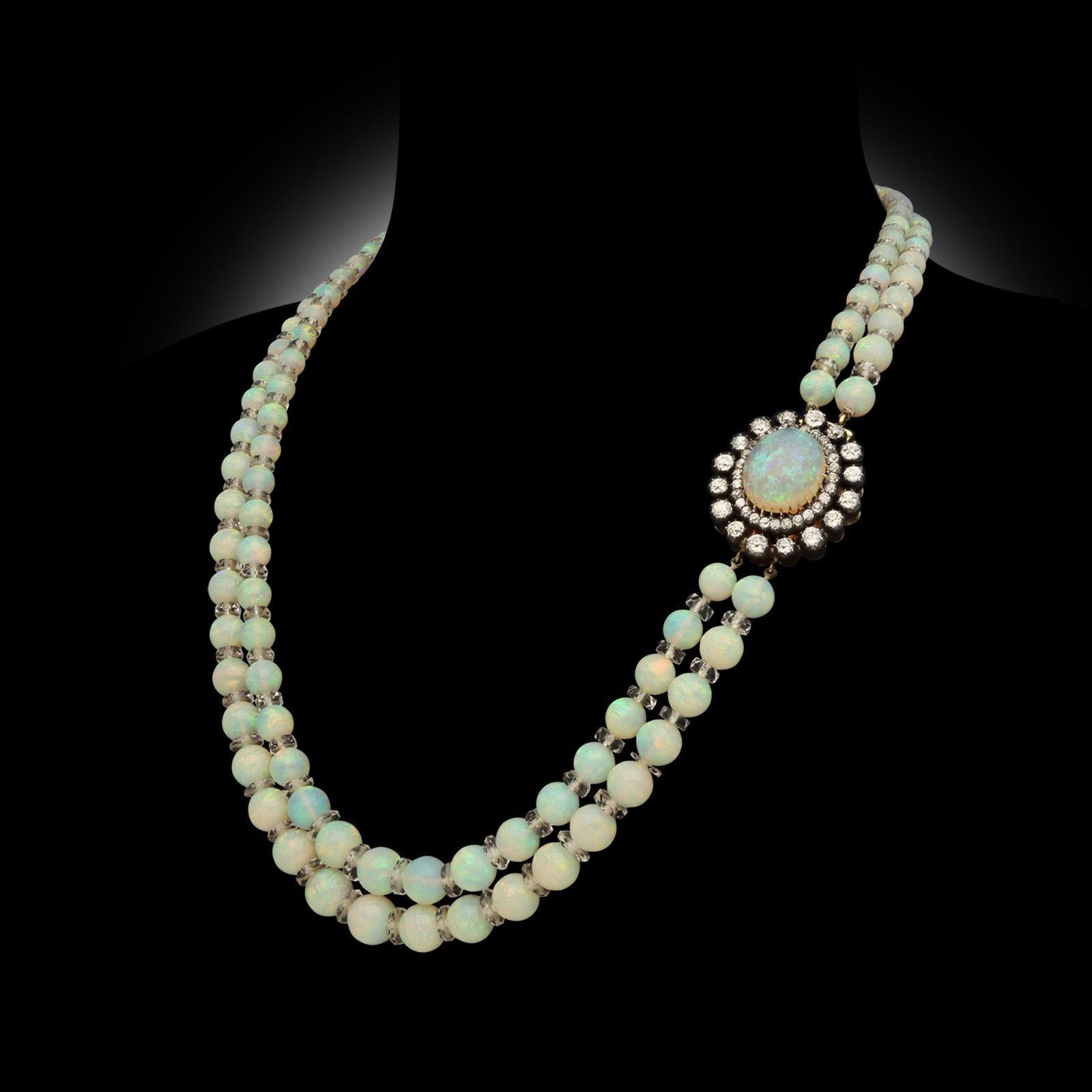 Collier ancien à deux rangs d'opales précieuses, vers 1910. Le collier comporte 132 perles d'opale naturelle de taille variable, enfilées entre des rondelles de cristal de roche facetté et fermées sur le côté par un cabochon d'opale naturelle et un