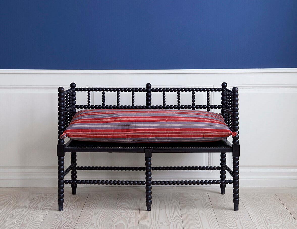 England, 1830s

Antique two-seater bench with an ebonised and bobbin-turned frame. 

The seat is upholstered in green velvet with brass tacks, here covered by a down pillow in Swedish Ticking.   

H 78.5 x W 103 x D 45 cm
