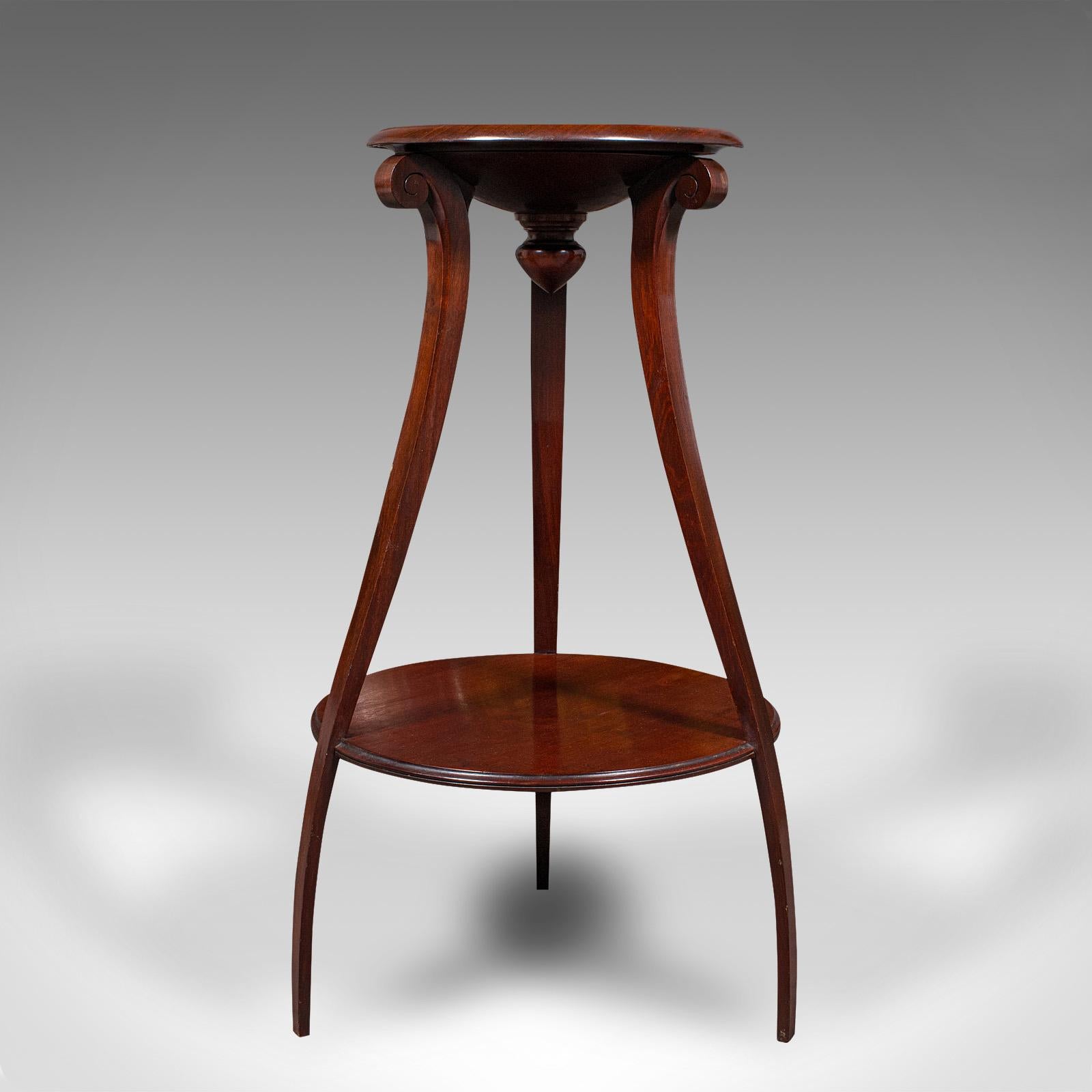 Se trata de una jardinera antigua de dos pisos. Pie de tarta o torchère inglés, de caoba, de principios de la época victoriana, hacia 1840. Rica en carácter y forma, esta pieza versátil ofrece magníficas opciones de exposición con un atractivo