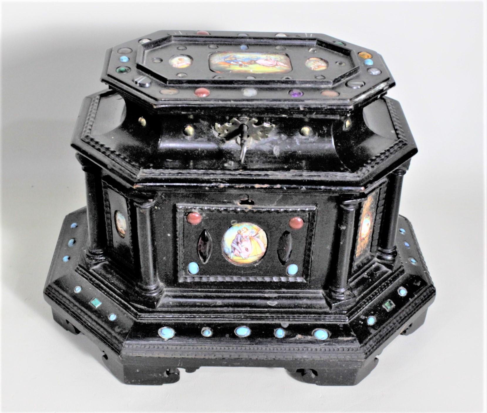This antique and elaborate wooden jewelry casket or box is unsigned, but presumed to have been made in Austria in approximately 1880 in a Gothic Revival style. The box has two tiers and an octagonal shape with beaded moldings and pillars. The two