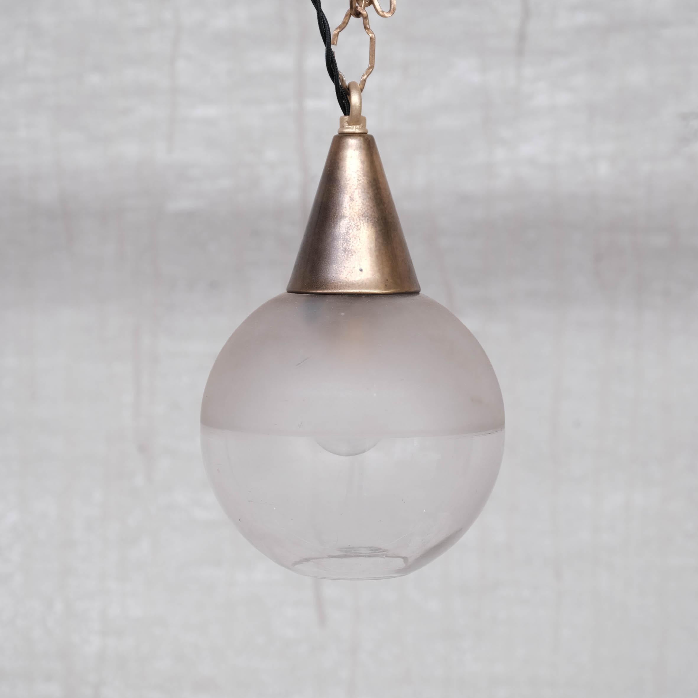 A diminutive two tone pendant light. 

Brass conical gallery, opaque half shade, clear base shade. 

France, c1920s. 

Open at the base. 

Good condition. 

Re-wired and PAT tested. 

No original chain or ceiling rose was retained with