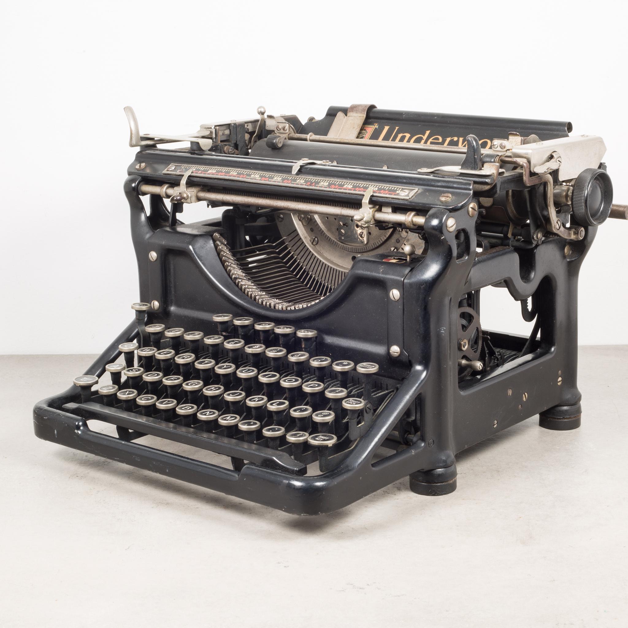 À propos de

Il s'agit d'une machine à écrire originale Underwood #4 avec un chariot de 16 pouces et une conception à cadre ouvert. Le numéro de série est 4077266-10 estampé à l'intérieur. Les touches sont en nickel et en noir. Cette machine à