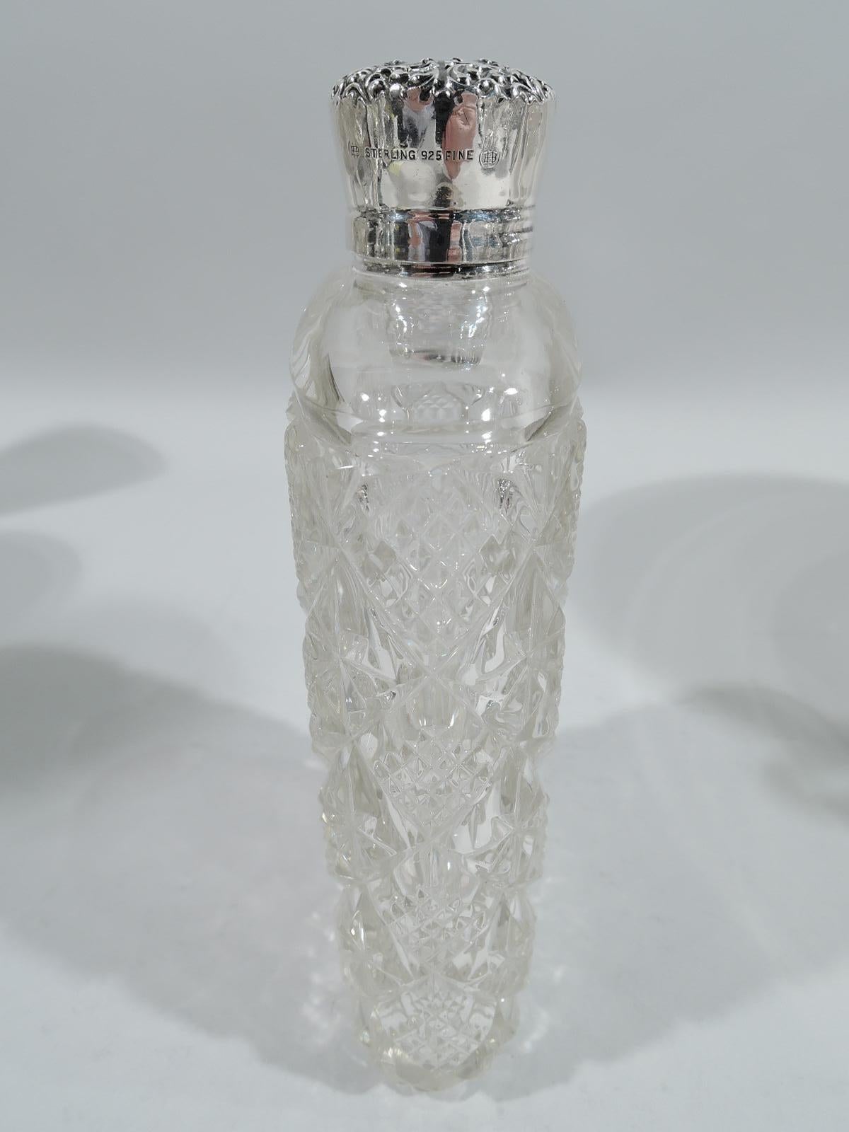Turn-of-the-century sterling silver and brilliant-cut glass flask Made by Unger Bros in Newark. Rectilinear with curved sides and diaper inset with alternating paterae and diaper. Threaded sterling silver collar and cover with plain sides and