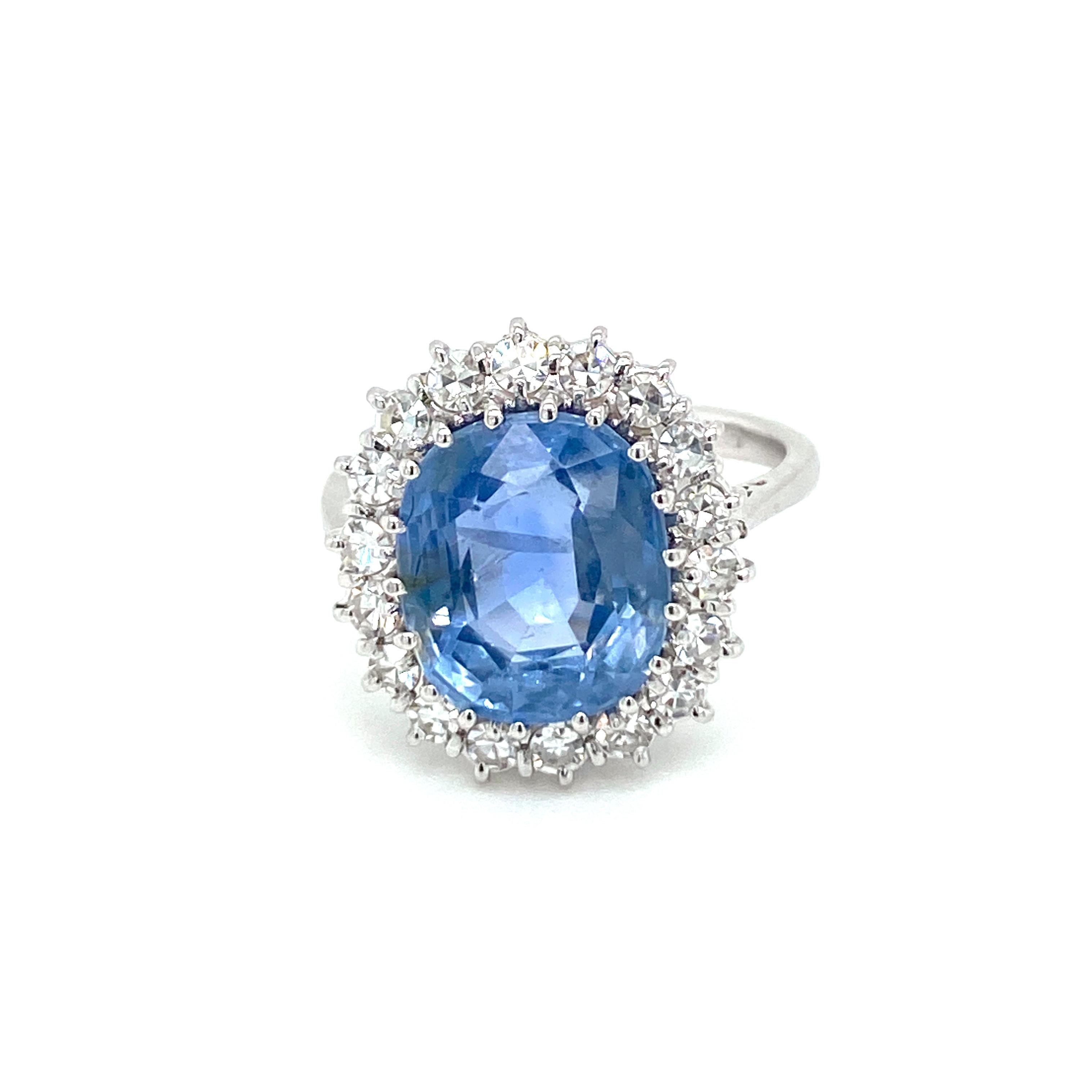 Beautiful ring set with an oval mixed cut Natural Unheated Ceylon Sapphire, weighing. 6.48 carats, surrounded by sparkling old mine-cut diamonds, weighing all together 0.70 cts. and graded G Color Vvs clarity.

Handcrafted in 18k white gold, origin