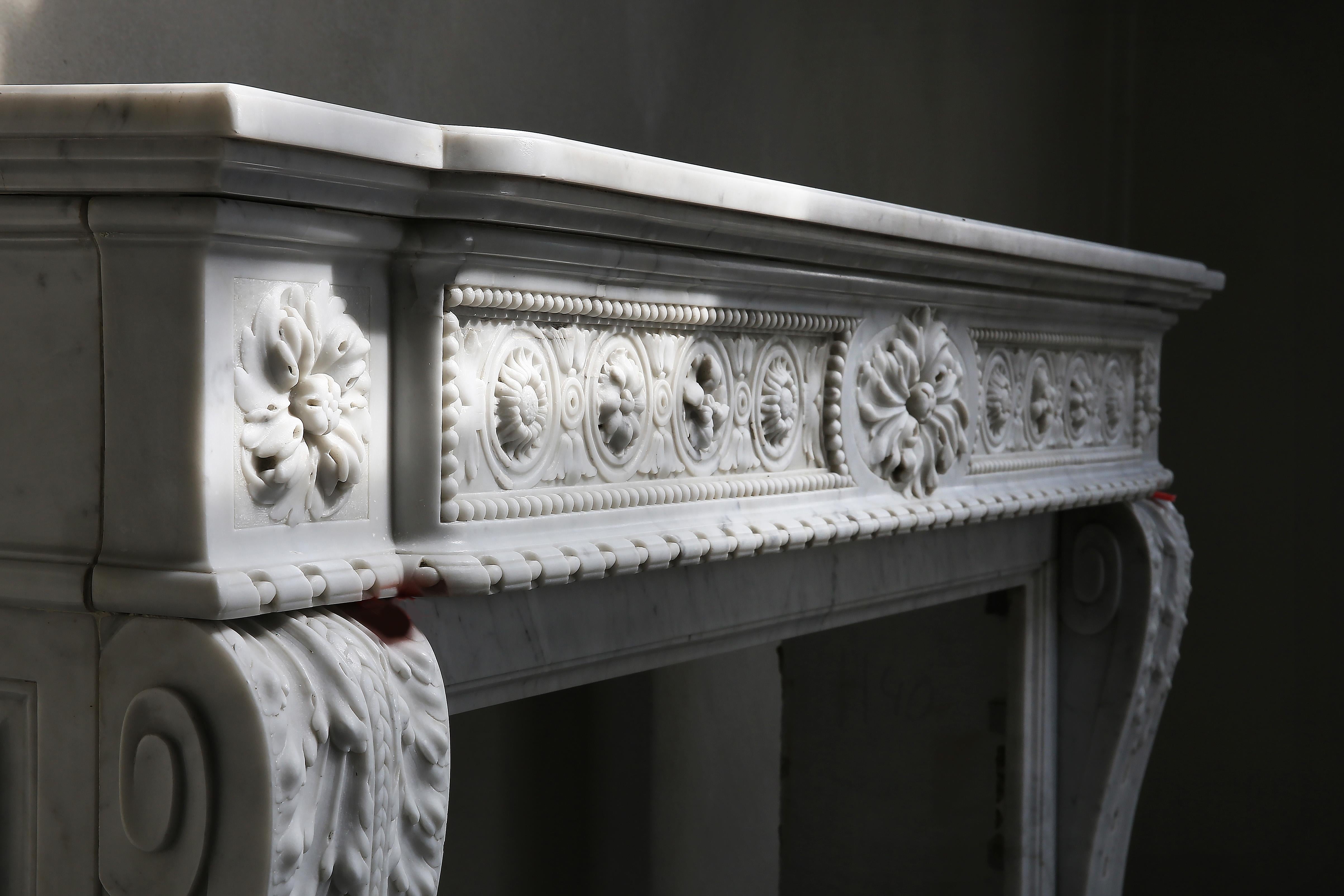 Special and exclusive antique fireplace made of Carrara marble! This fireplace in the style of Louis XVI dates from the 18th century. The top is richly decorated with various elegant ornaments. The legs are provided with acanthus leaves and are