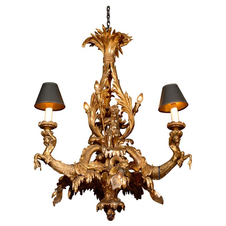 A Superb Gilt Bronze Rocailli Chandelier with Nautical Elements, depicting Mermen, Dolphins and Cherubs with Tridents. Truly Unique.  France, circa 1900.
Dimensions: Height 43