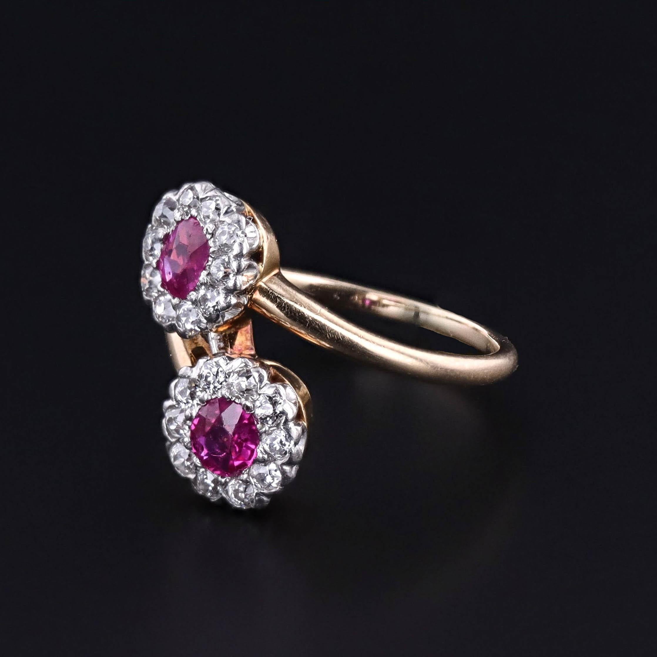 An antique bypass ring (circa 1910), featuring two natural, untreated rubies with halos of diamonds set in platinum with a 14k gold band.  The rubies are vivid purplish red color.  One weighs approximately 0.41ct and the other weighs approximately