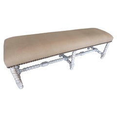 Banc rembourré ancien aux pieds tournés, finition bois dénudé.