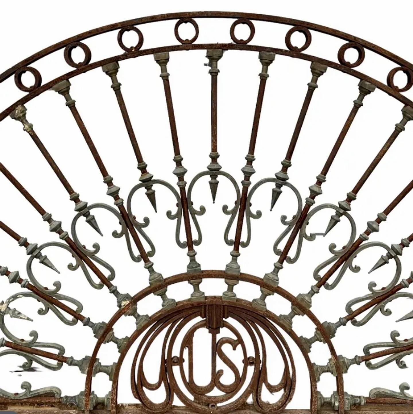 A rare and important late 19th / early 20th century American classical arched iron architectural fanlight header salvaged from a United States Embassy. 

Monumental size, lunete form, exceptionally executed stylized sunburt-like pediment sculpture