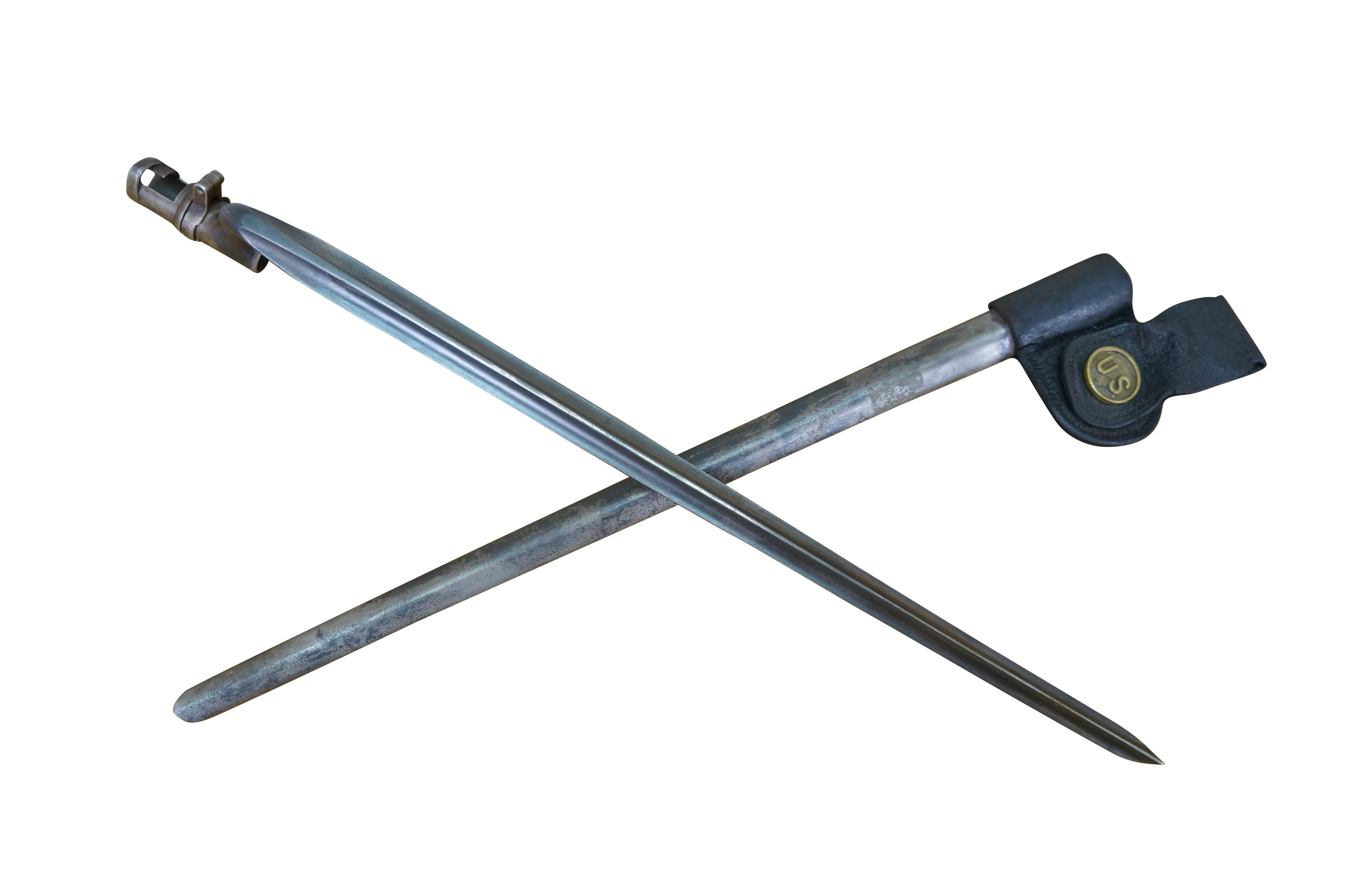 Bayoneta de casquillo militar de finales del siglo XIX de Estados Unidos para el fusil Trapdoor Springfield M1873. Hoja triangular fina y afilada con la punta ligeramente hacia arriba. Vaina metálica con ranilla de cuero negro y botón US de latón.