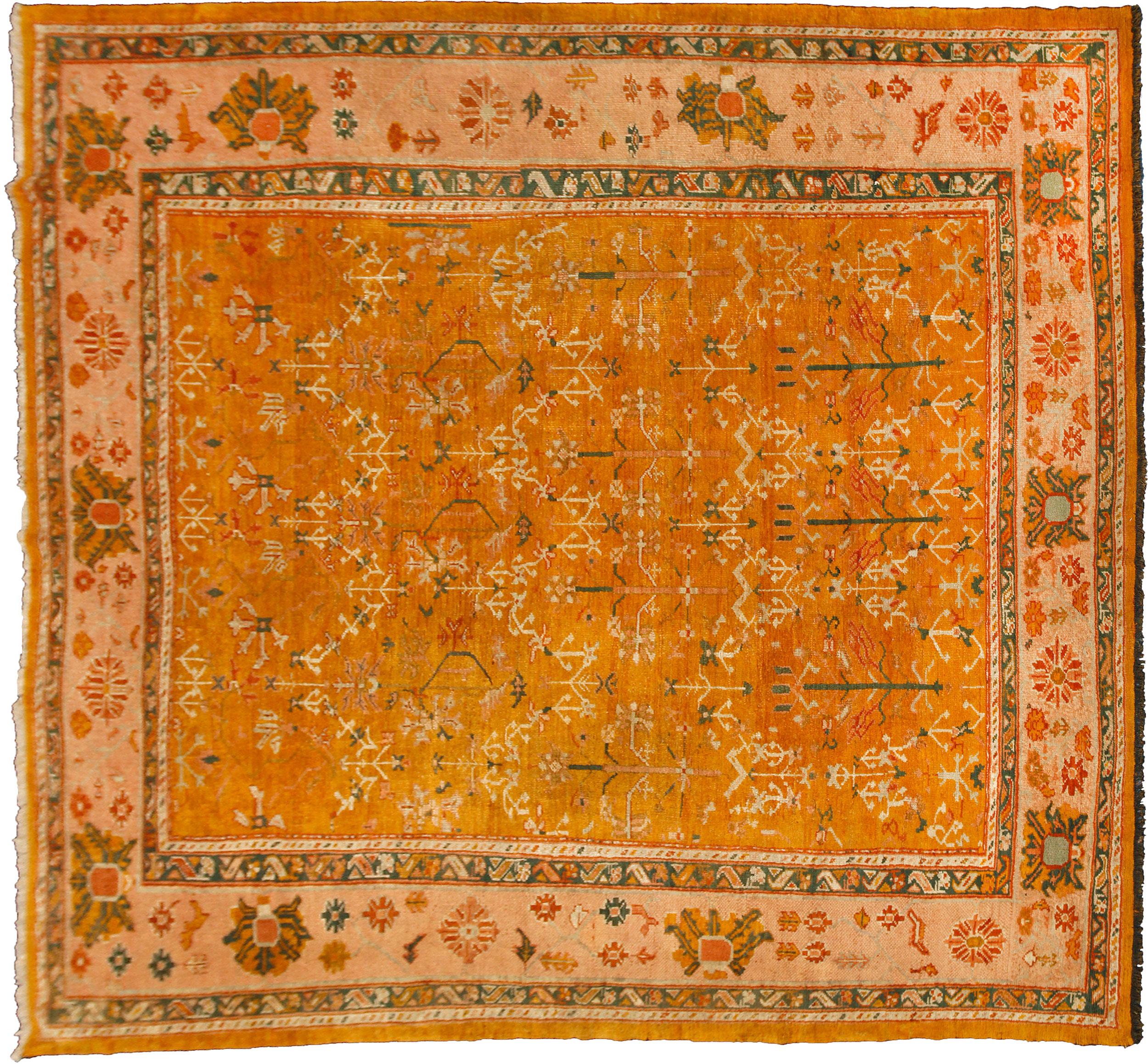 Seltener antiker Uschak-Teppich. Es ist sehr schwierig, Ushak in dieser quadratischen Größe zu finden. Der schöne gelbe Grund ist mit einem flächendeckenden Strauchmotiv und einer hellen, pfirsichfarbenen Blumenbordüre verziert, was dieses Stück