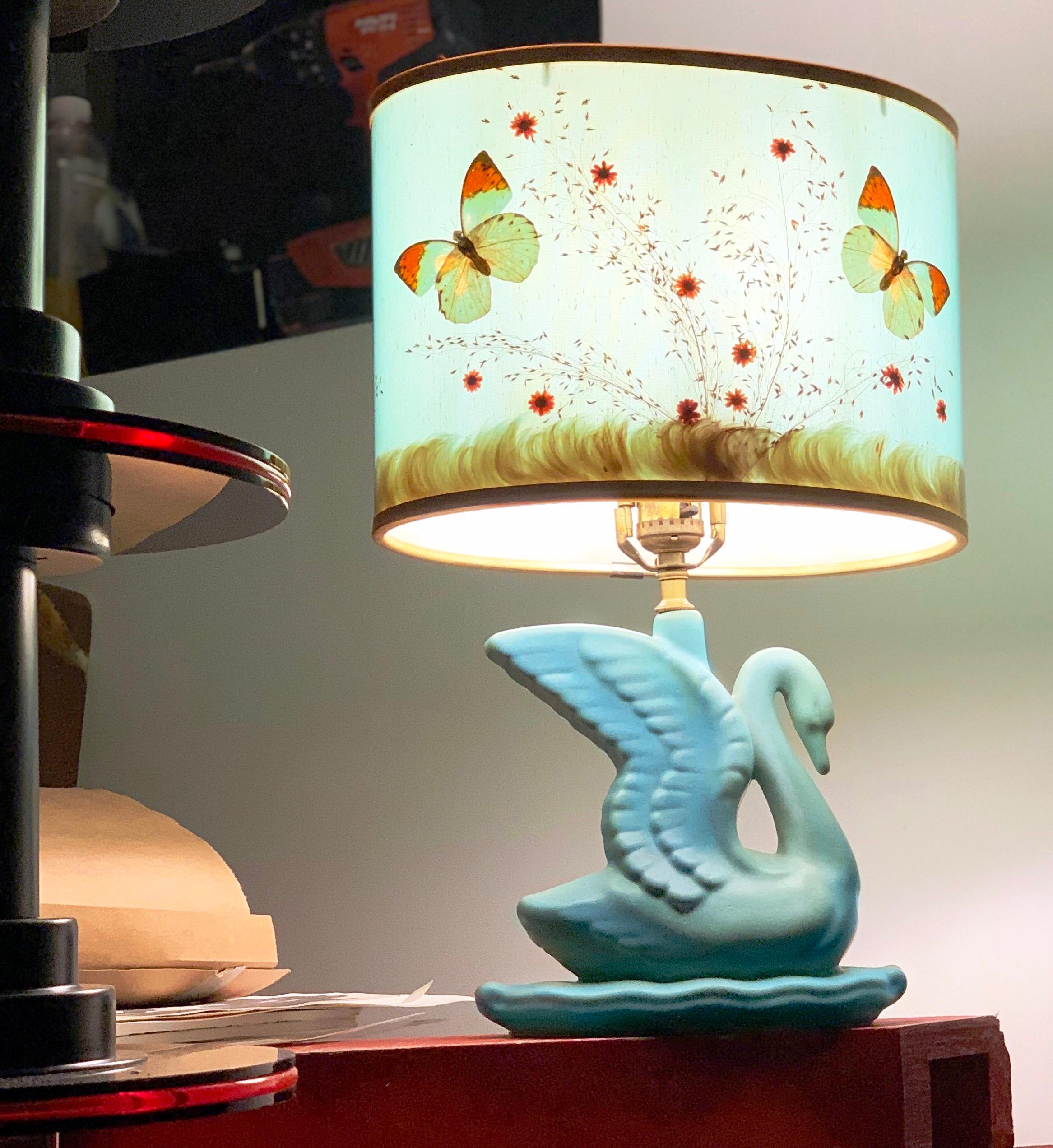 This is a vintage Van Briggle Swan lamp in the famed matte blue glaze that Van Briggle made its name with in the early years of the 20th century. It has the requisite Van Briggle mark at its base and is in excellent original vintage condition,