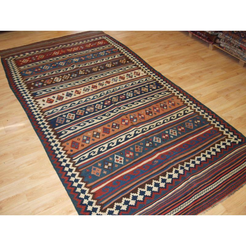 Antique Varamin kilim with excellent natural colours and traditional banded design.

A good example of a Varamin kilim, each of the bands contains a different design. The reciprocal border design is very typical for kilims from this region. Note the