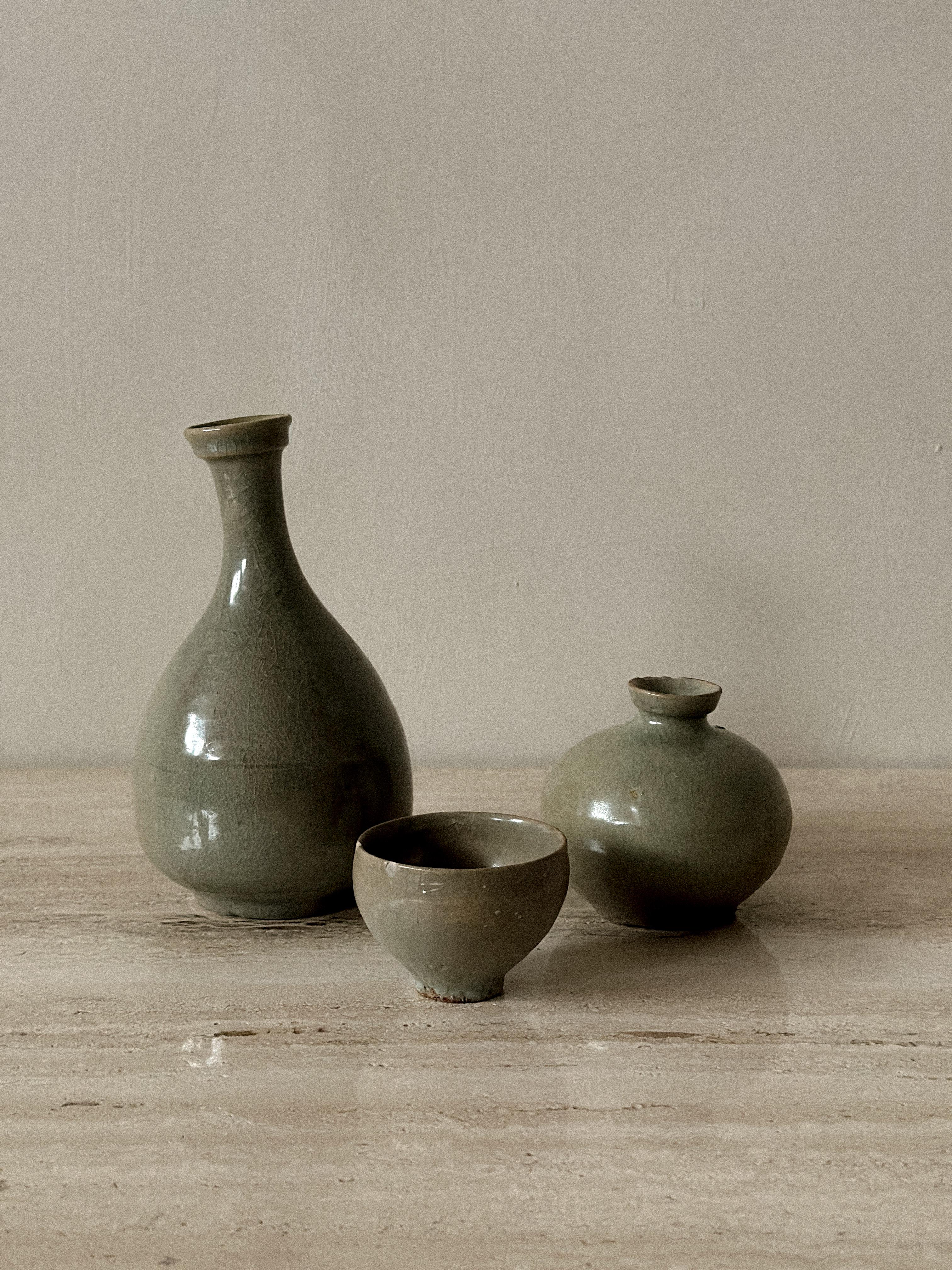 Three different pieces. All glazed in a thick, semi-opaque gray-green celadon glaze with fine crackling.

A vase: Yuhuchunping-like shape.
Height: approx. 20 cm

A spherical flask or jar.
Height: approx. 10 cm

A small cup.
Height: approx. 5.5 cm

