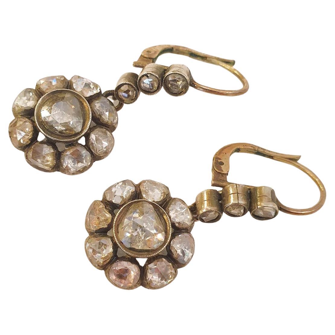 Pendiente antiguo colgante con diseño de cabeza floral centrado con un gran diamante talla rosa de facetas completas flanqueado con diamantes talla rosa de excelente chispa con un peso estimado de 3 quilates los pendientes son de oro de 10 quilates