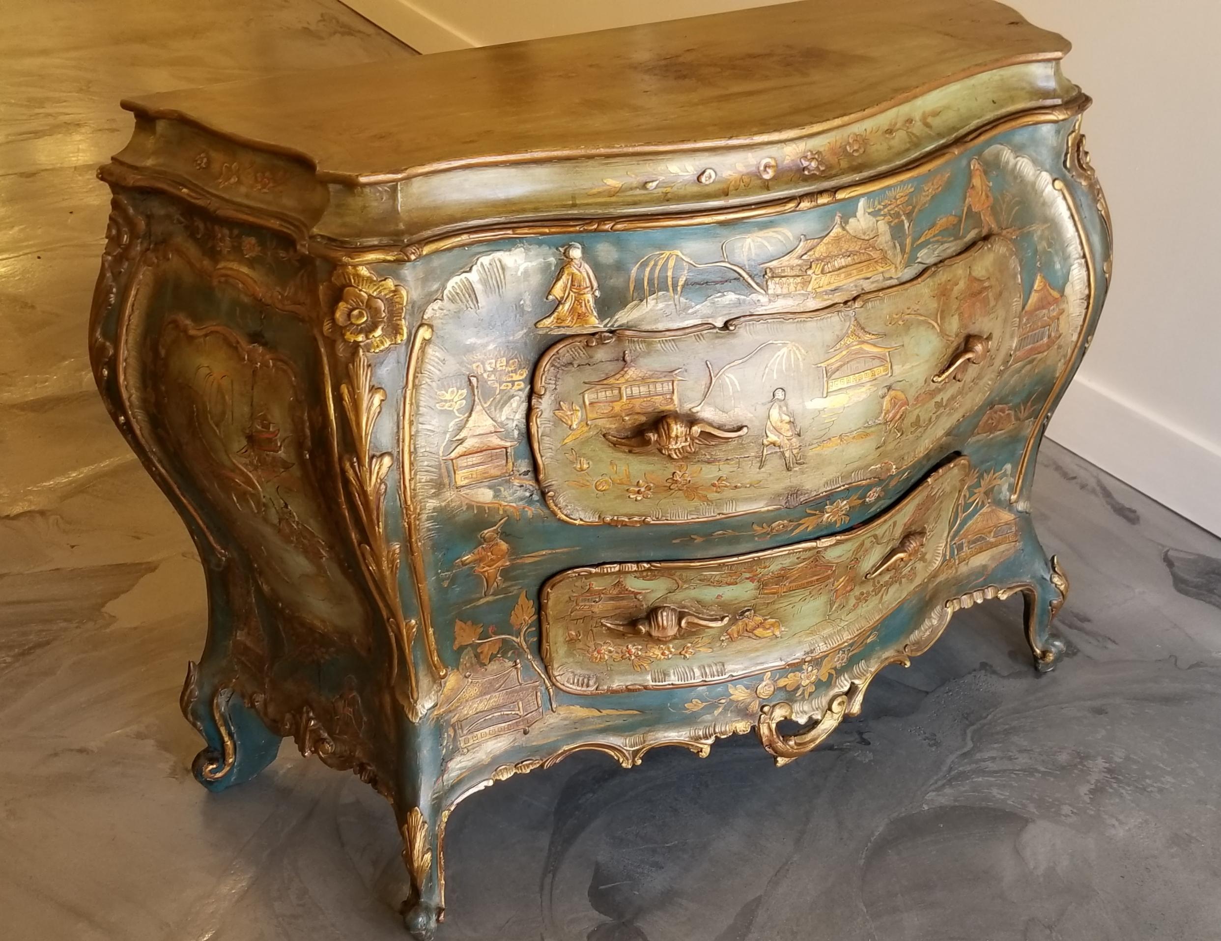 A stunning and fine 18th century Italian commode embellished with hand lacquered chinoiserie detail. Over-exaggerated Bombe form with warm blue, green and gold tones. Retains original 18th century chinoiserie lacquer decoration and original carcass.