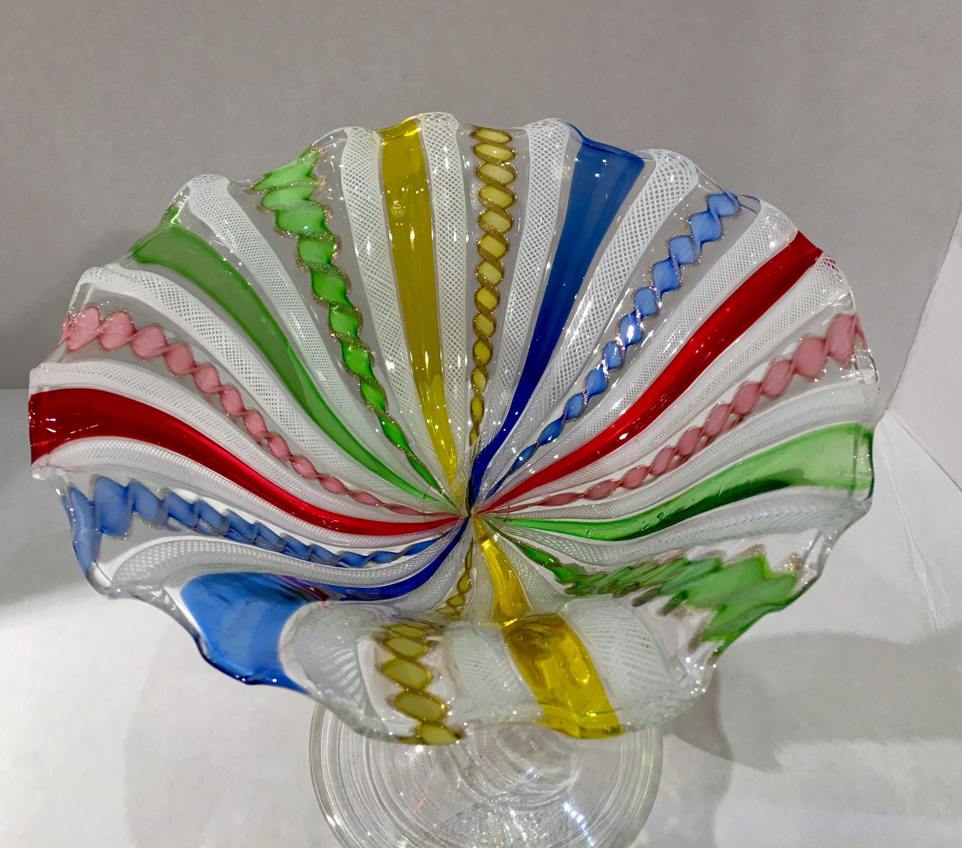 Pristine, handmade antique ruffled compote dish with a graceful swan stem from the Venetian island of Murano in Northern Italy, features white latticino ribbons or zanfirico canes, alternating with brilliantly colored ribbons of solid color and