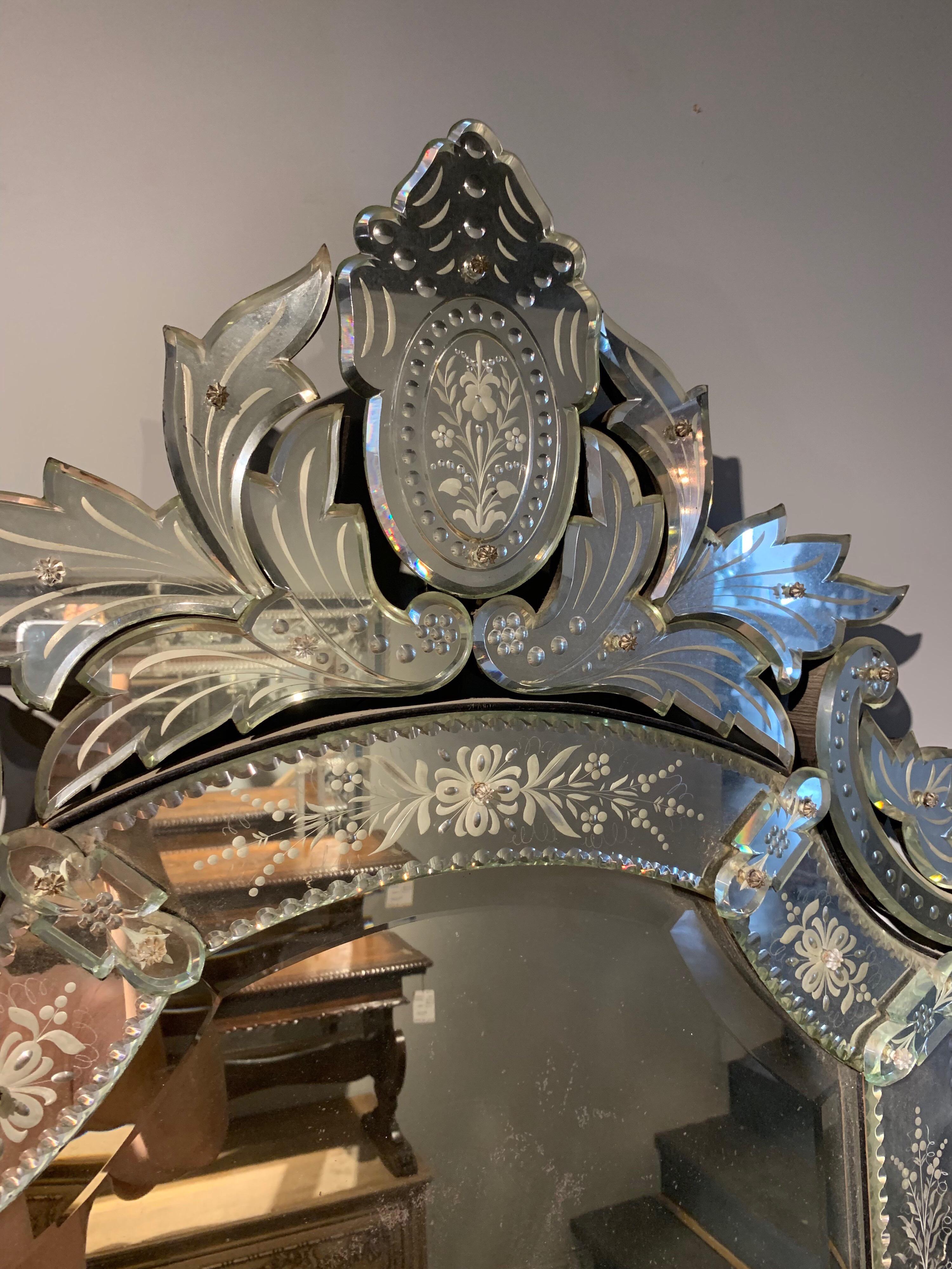 Superb antique Venetian etched glass mirror. Beautiful etching of flowers and there is a crown at the top of the mirror as well as other scrolls along the edges. Makes an impressive statement.
