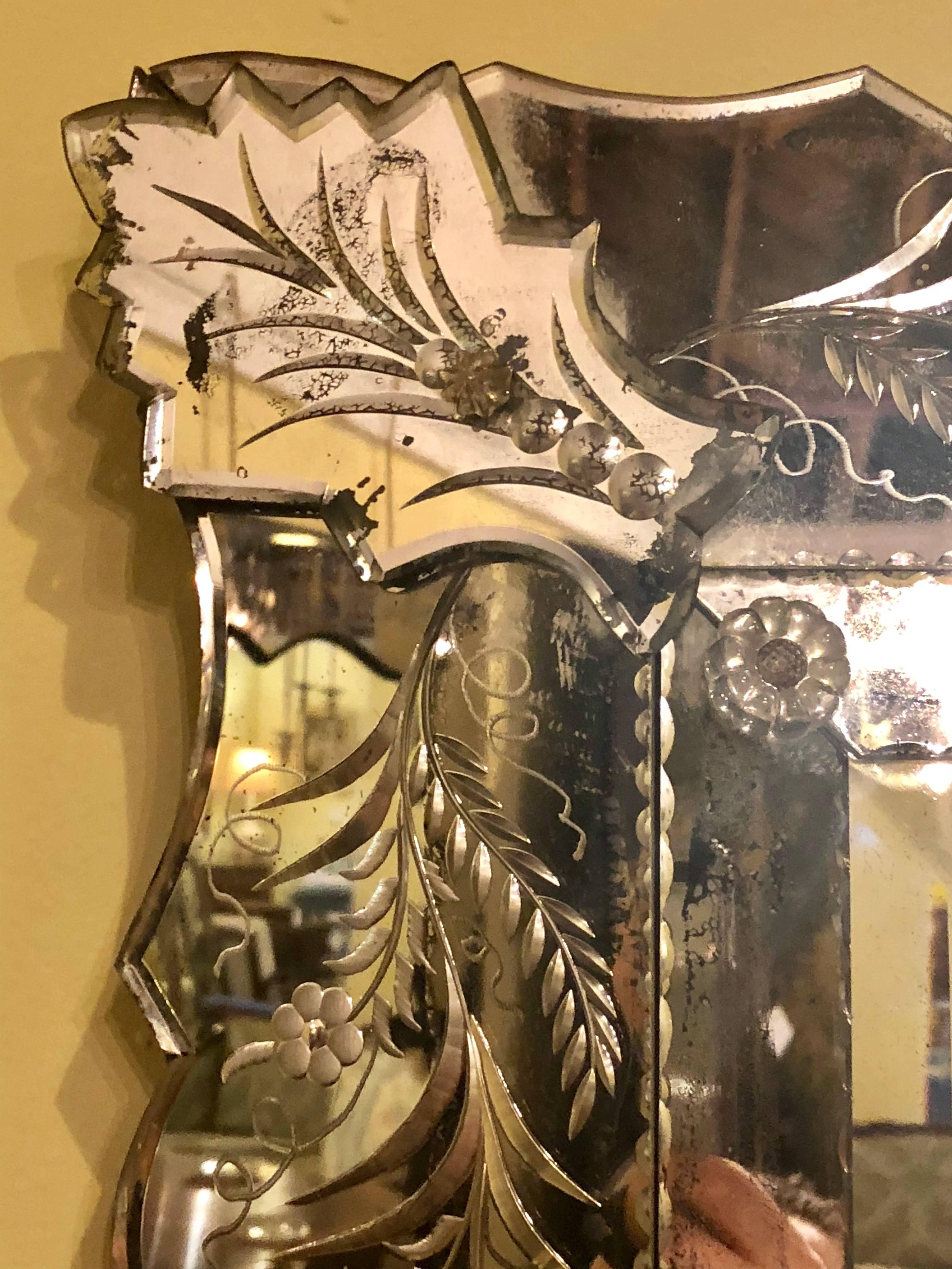 An Antique Venetian etched glass wall or console mirror. The centre bevelled mirror with in thin cut mirror frame sitting inside of a much thicker etched glass frame. One corner floral with a crack as photographed.