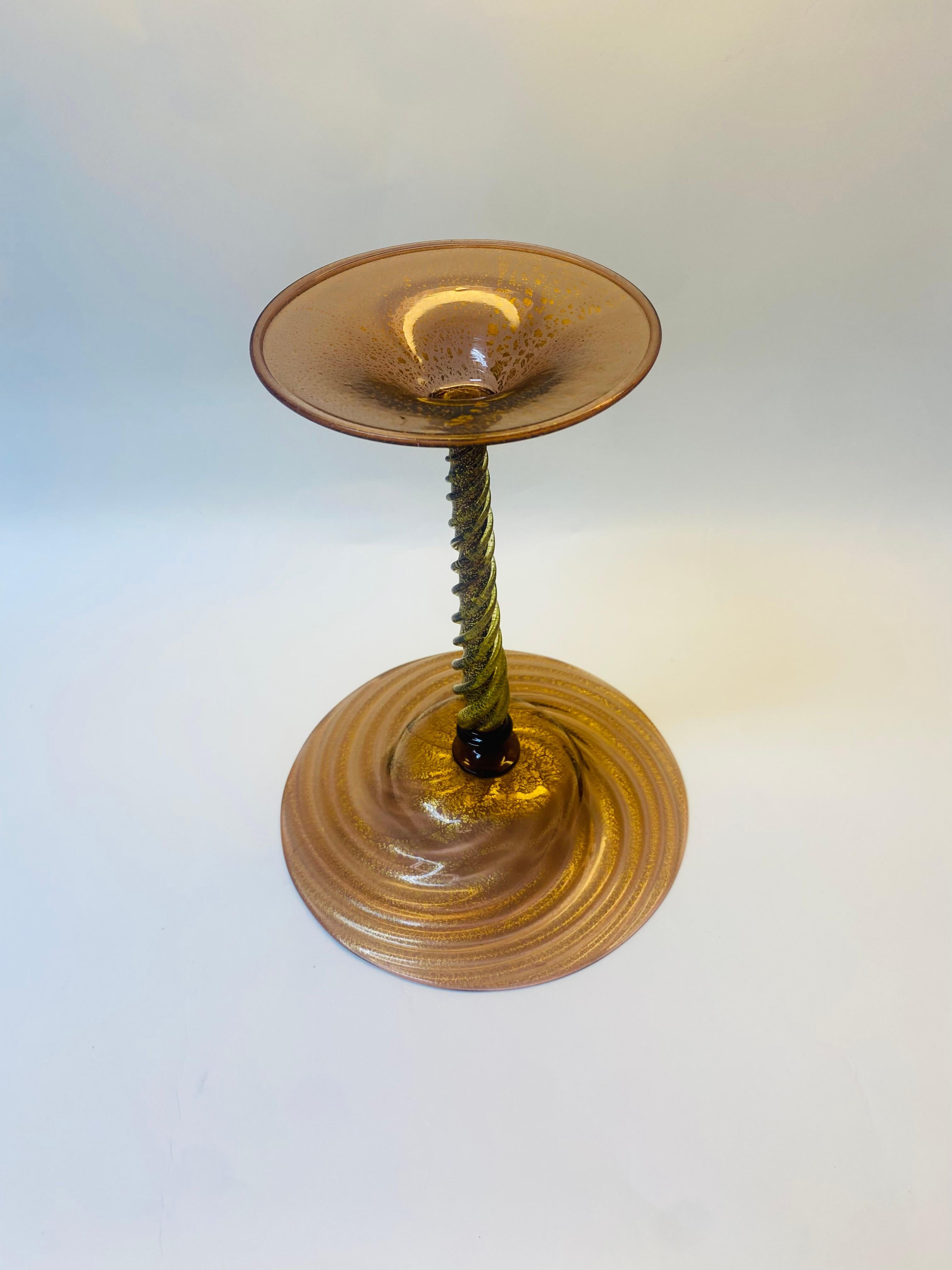 Une pièce intéressante et vibrante de verre soufflé provenant de l'île de Murano, à Venise, en Italie. Grande et dotée d'une tige torsadée intéressante, cette pièce sera ravissante pour votre table ou votre présentoir à desserts, ou tout simplement