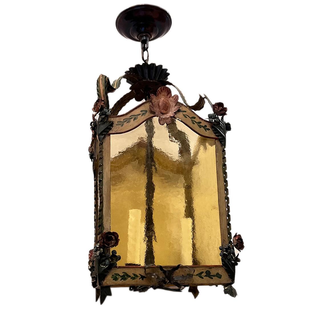 Vers 1920, lanterne vénitienne en métal peint avec verre ambre.  3 lumières.

Mesures :
Hauteur totale de la chute : 28.5