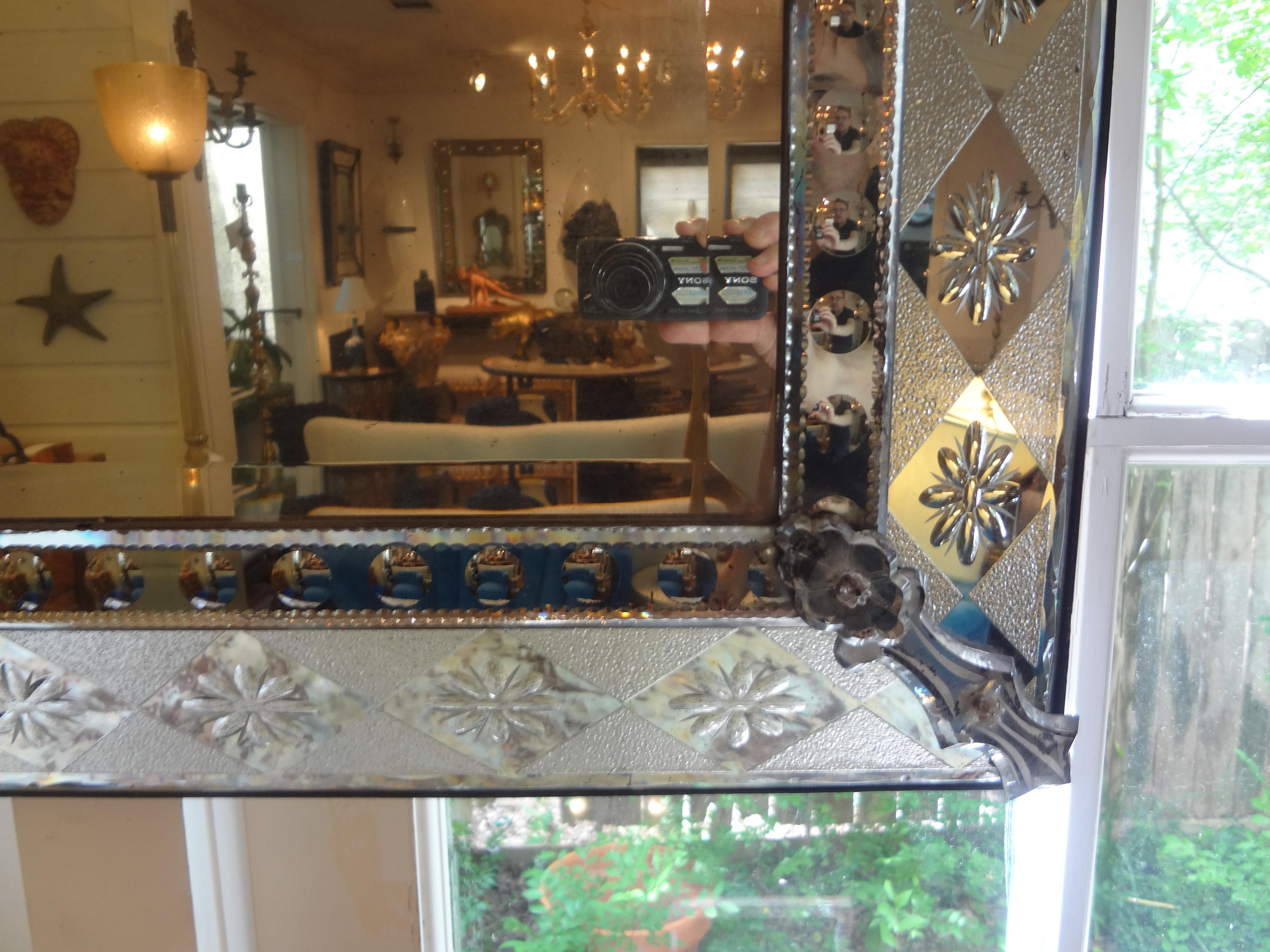 Antique Venetian mirror with geometric design. This highly unusual Art Deco Venetian mirror has a stunning geometric design with a beveled central mirror. Perfect above a console, commode, credenza or in an entrance hall or powder room.