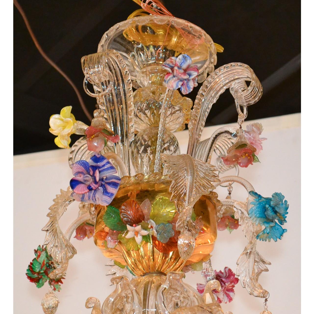 Fabulous antique Venetian blown glass and gilt brass twelve-light chandelier featuring and extraordinary array of colorful flowers and leaves depicted in relief. The shaped stem with large leaf sprays above beautifully contoured arms with fluted