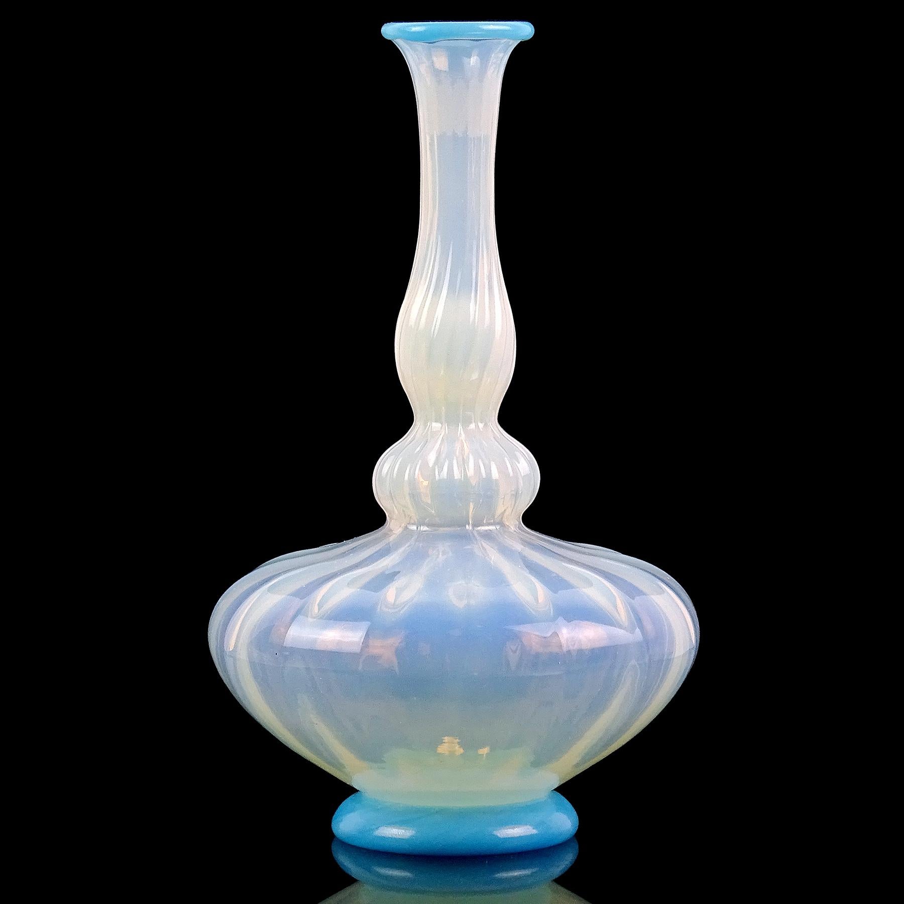 Beautiful antique Venetian / early Murano hand blown opalescent white and blue Italian art glass flower vase. It has a genie bottle shape, with pleated surface on the body. It has sky blue accents on the rim of the vase, and the bottom base. The