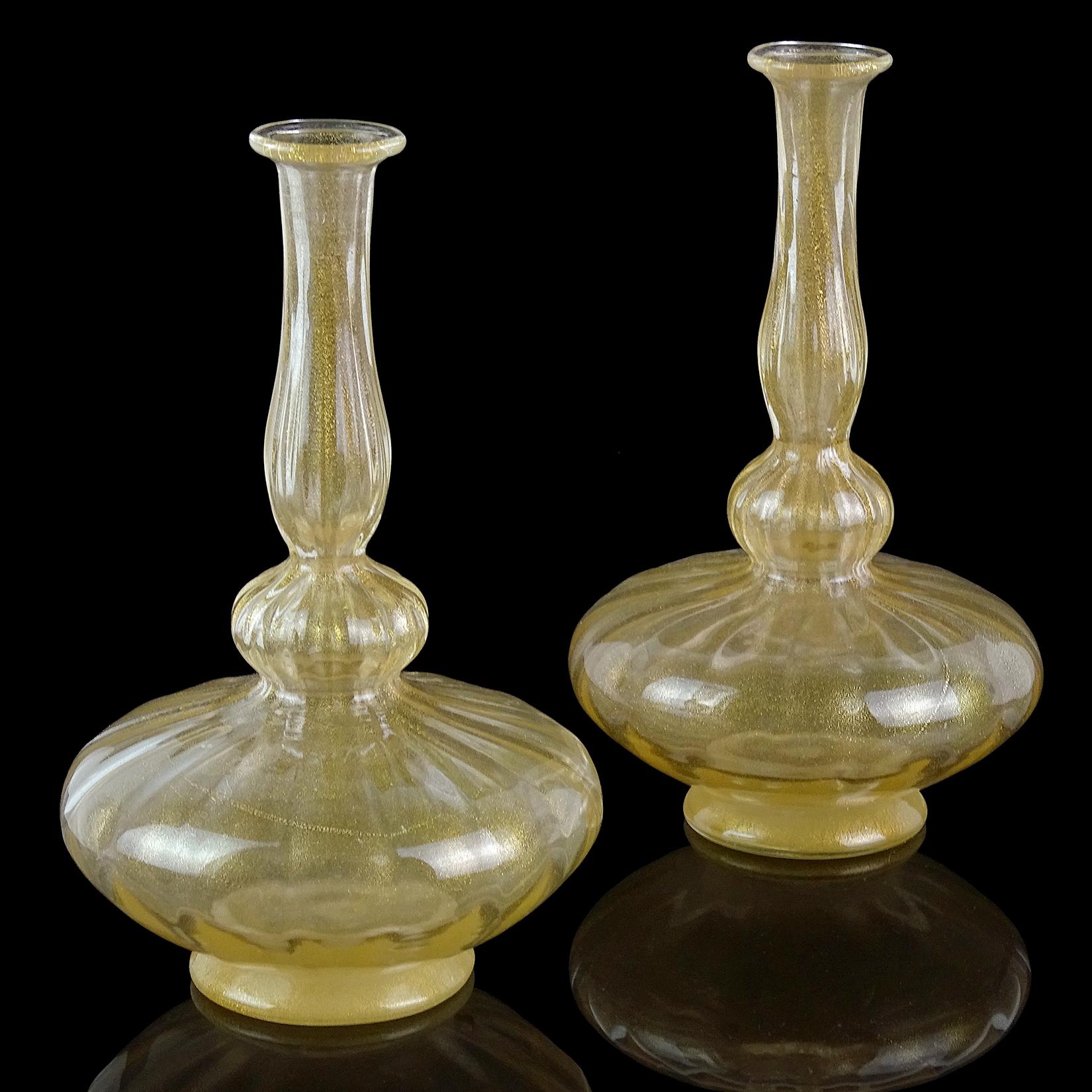 Beautiful set of 2 antique Venetian / early Murano hand blown gold leaf Italian art glass vases. They have a genie bottle shape, with pleated surface, and gold disks on the bottom. Created in the manner of the Seguso Vetri d'Arte and Salviati