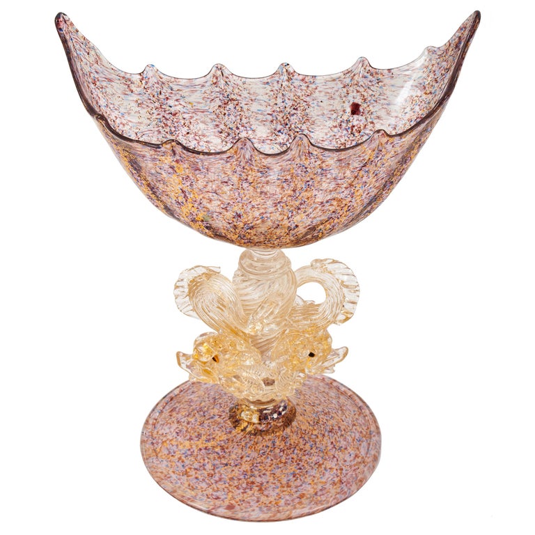 A good antique Italian Venetian Art Nouveau hand blown glass couple/centerpiece, by Salviati, circa 1910.
The coupe having a boat shaped bowl and is raised on a pedestal supported by a pair of dolphins and terminating to a circular flared foot. The