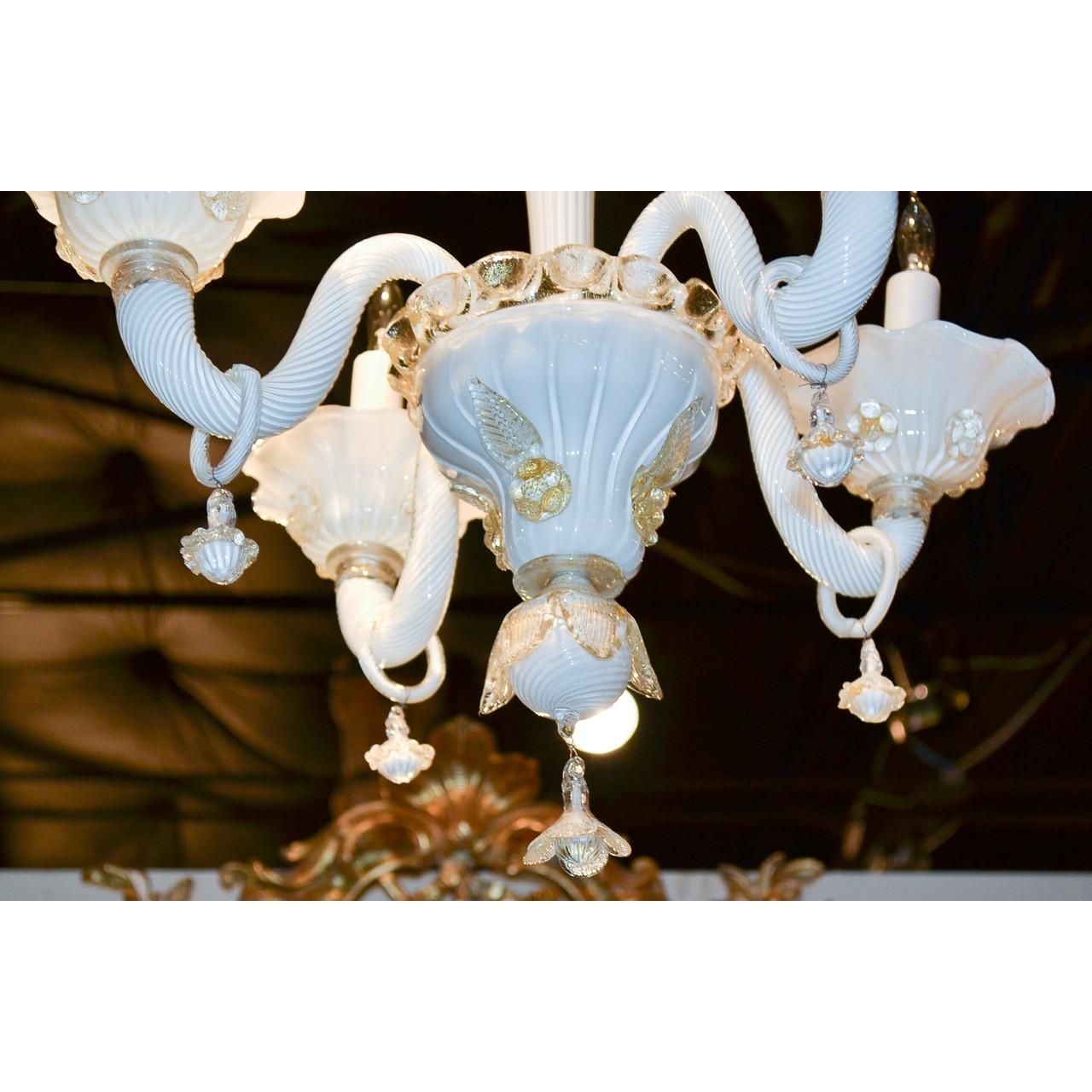 Lovely antique Venetian opalescent glass chandelier in wonderful hues of blue, pale pink, and hints of amber. The bulbous and tapered stem decorated with glass flower heads in relief. Mounted with four swirl-pattern scrolled arms with ring pendants