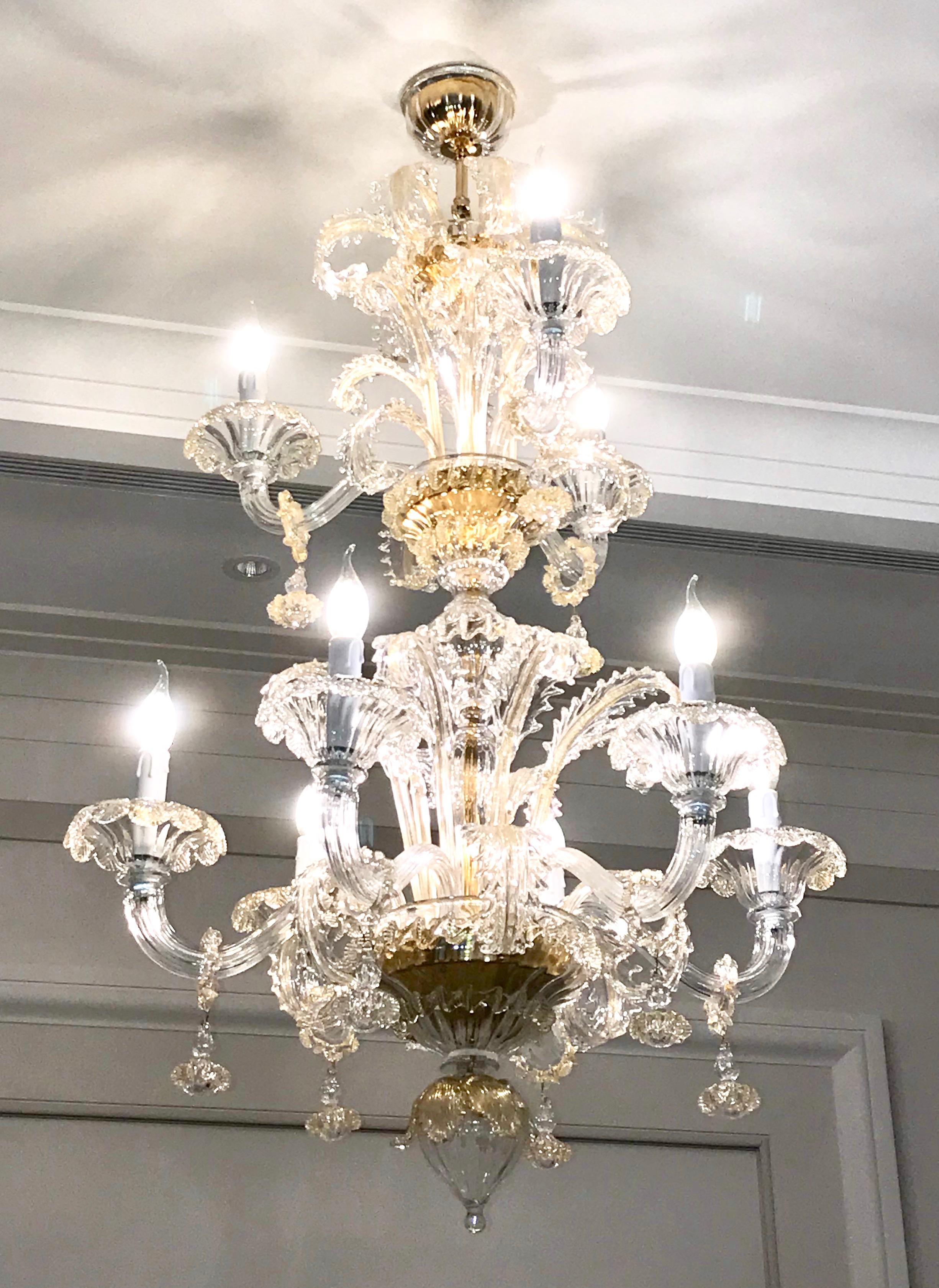 This contemporary Italian chandelier, entirely blown and handcrafted in Italy, in Baroque Rezzonico style, is a high-quality Art Work, in crystal clear Murano glass highlighted by 24-karat pure gold accents. It is composed of 2 tiers, the lowest one