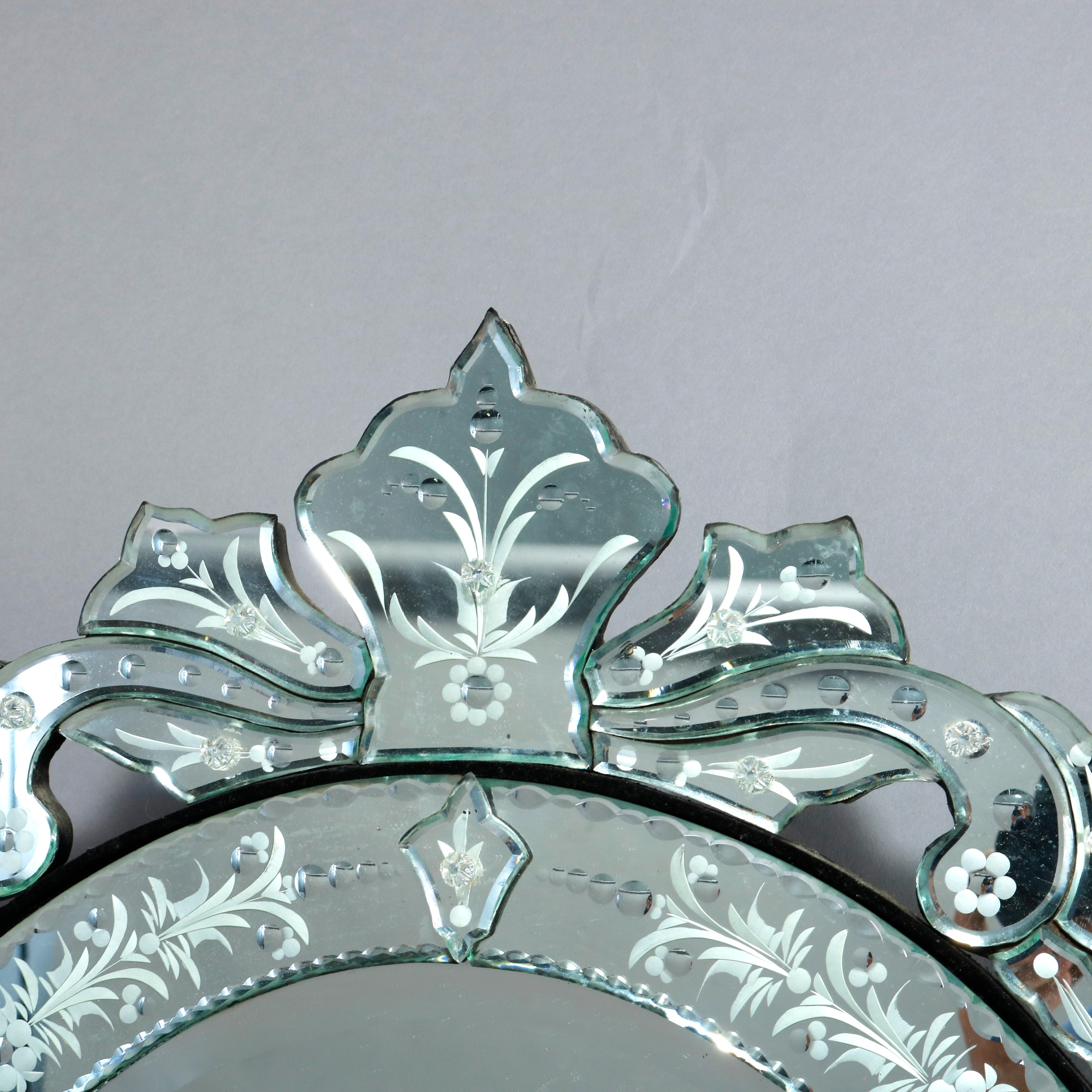An antique Venetian style wall mirror offers round form with scroll and foliate crest surmounting round mirror, foliate and floral etching throughout, 20th century

Measures: 28.5